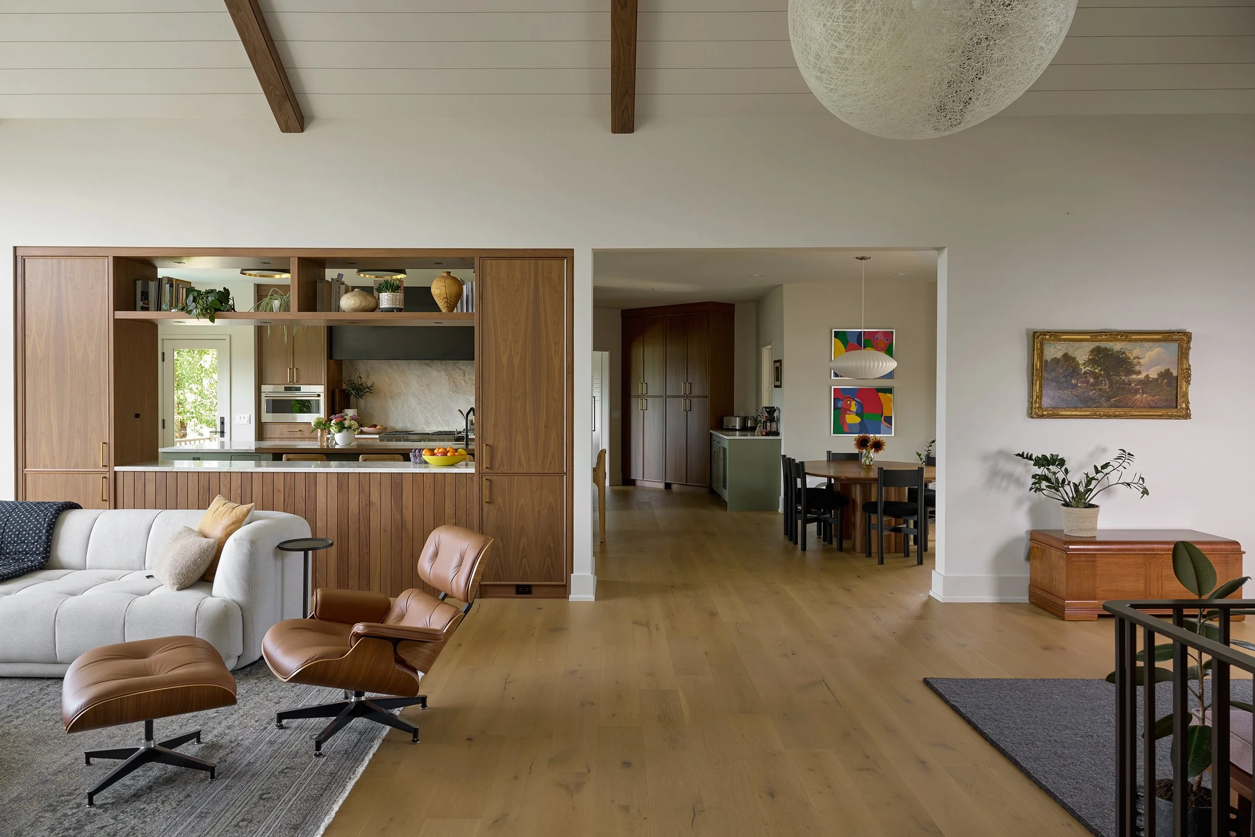 View from living room through open concept kitchen and family dining room with pendant light and dining table