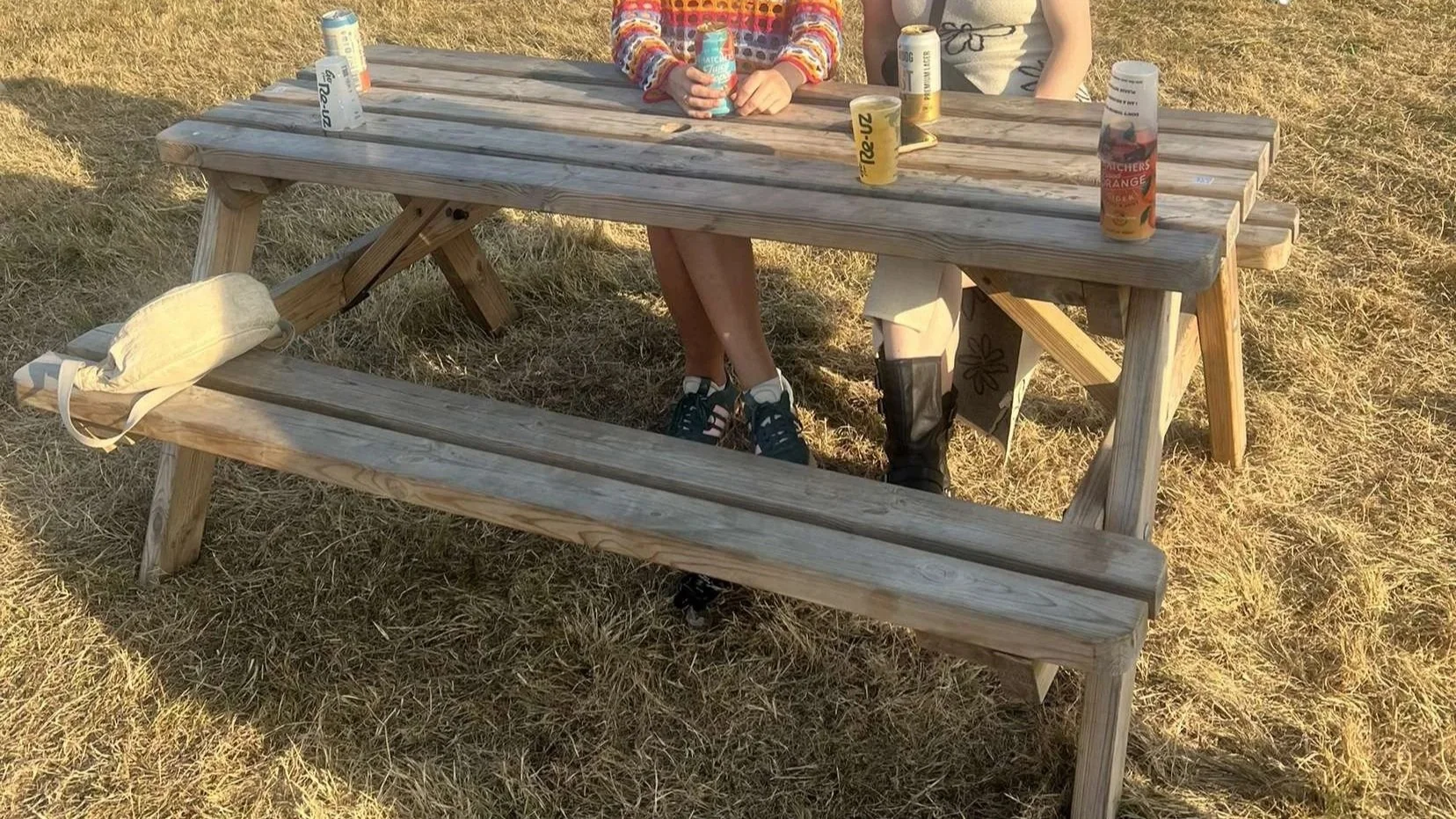 Wooden picnic bench at a festival in Cornwall. High quality on a grassy field.