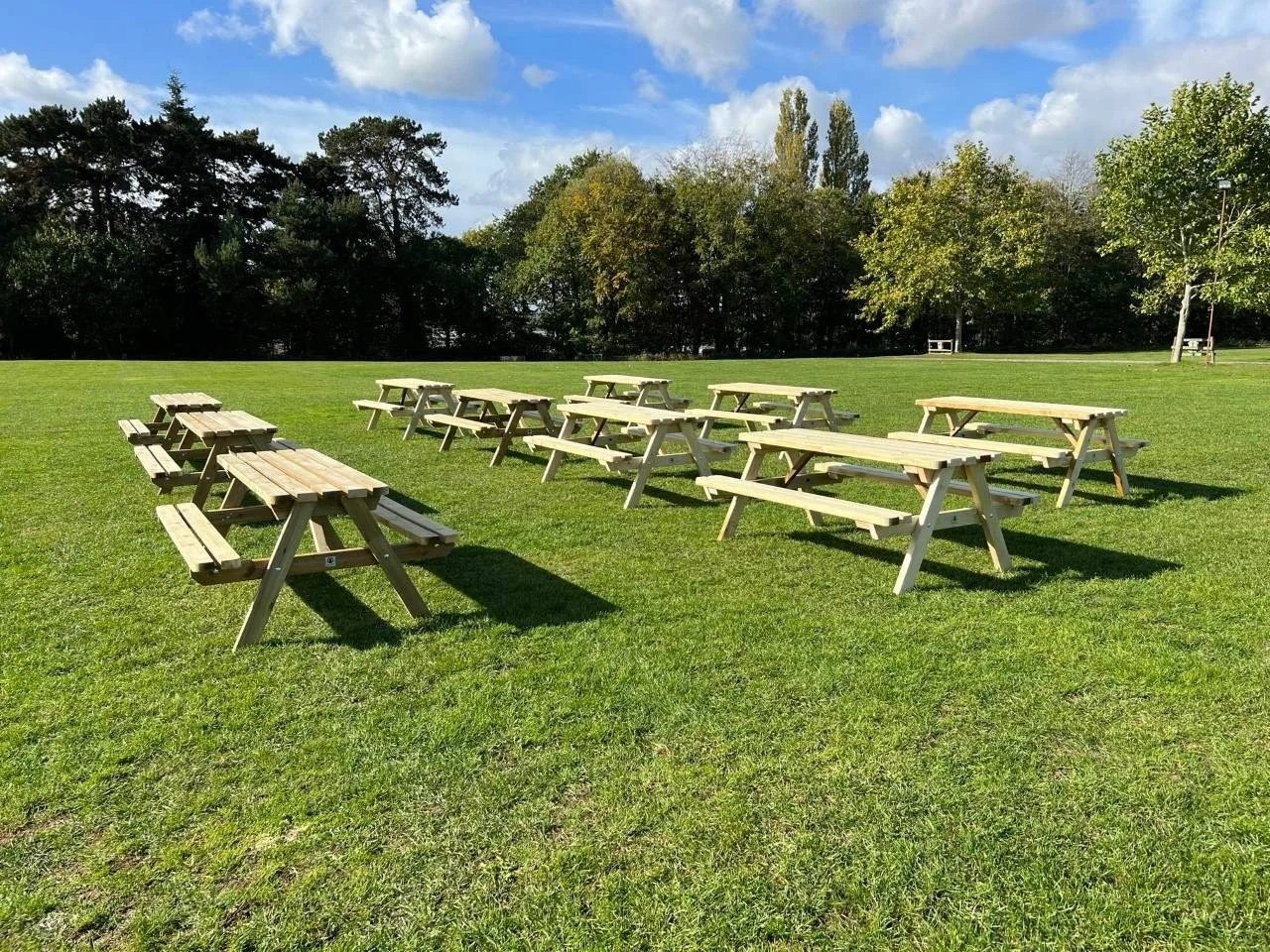 High quality picnic benches at a local community event in a field.