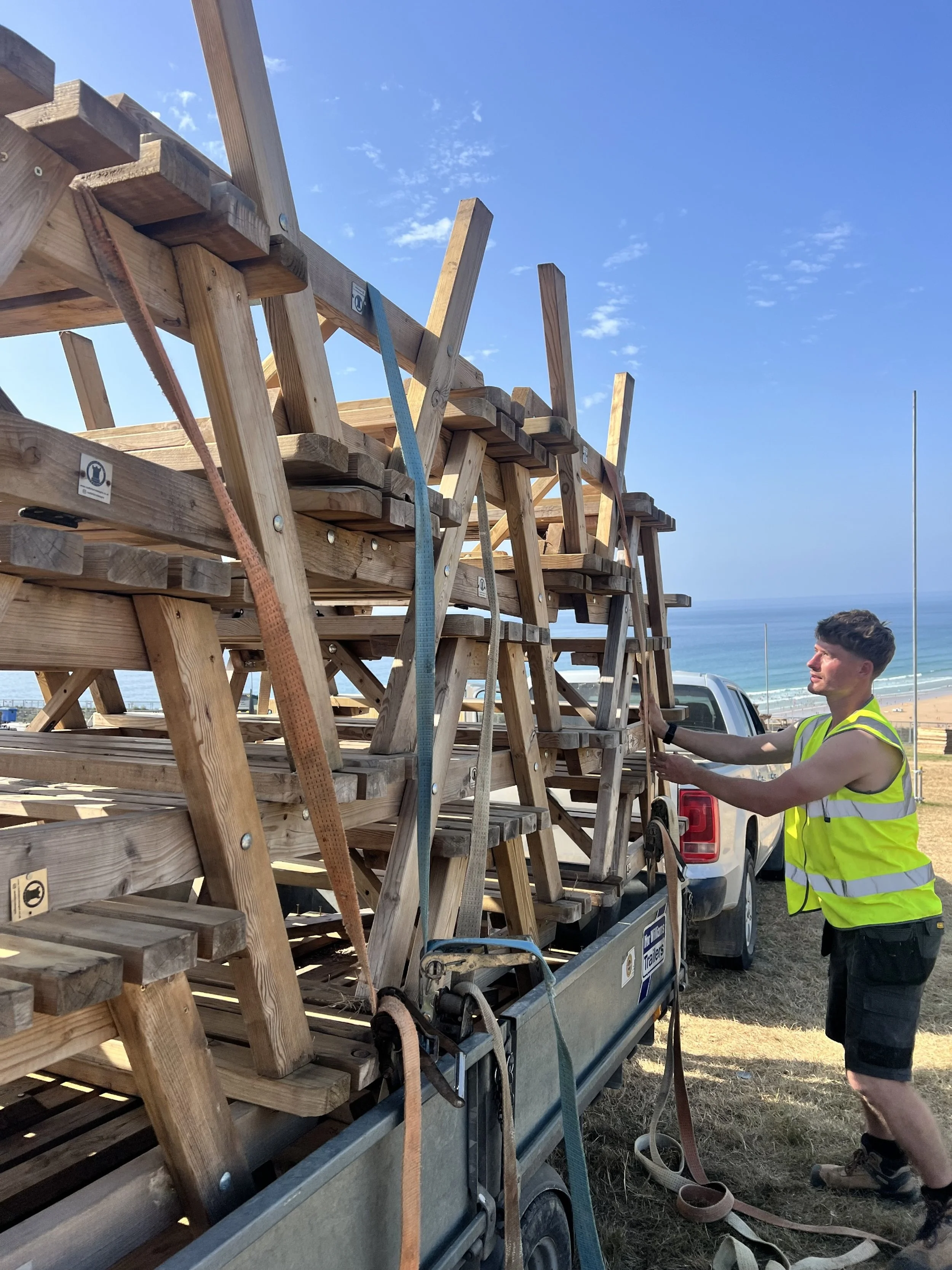 Picnic benches being set up for a festival in cornwall. 