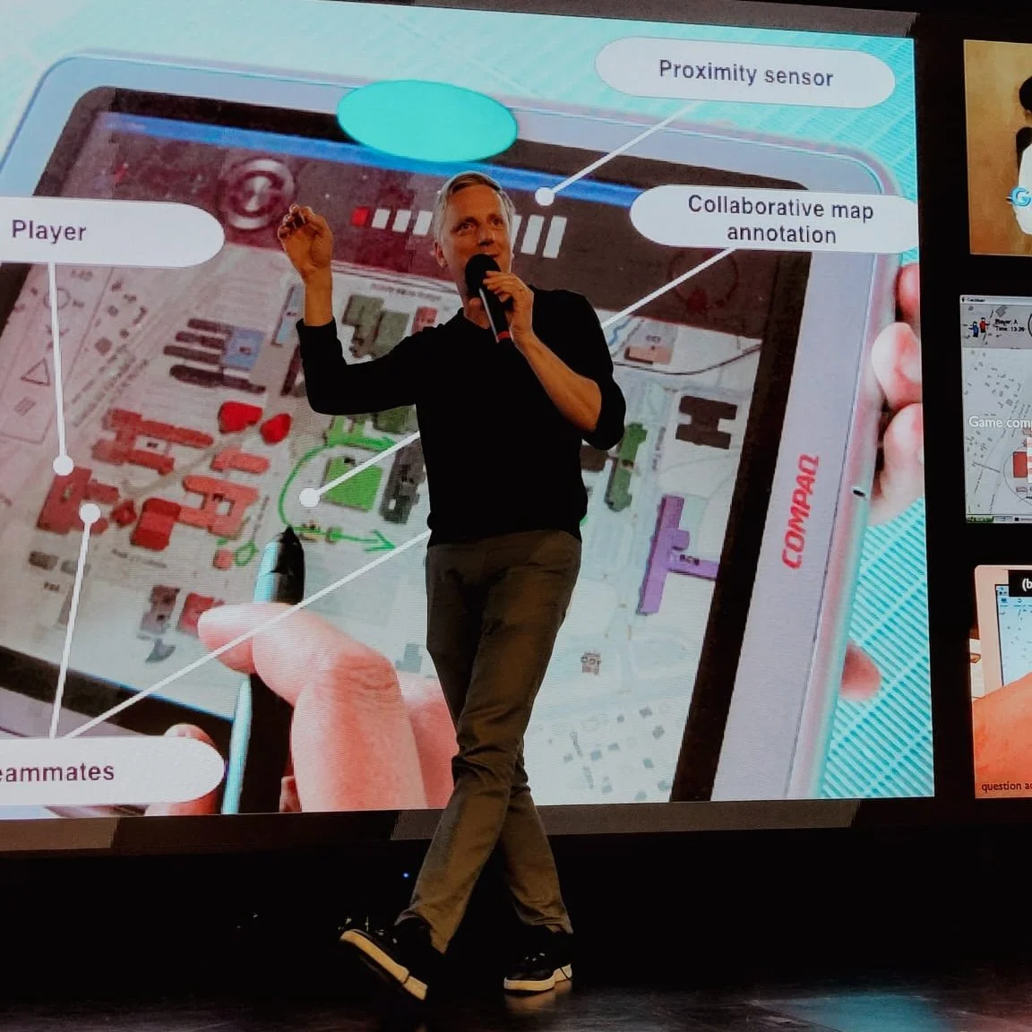 Fabien Girardin speaking with a microphone on stage, presenting a collaborative map annotation project with proximity sensors and location-based interaction design visible on the screen behind him.