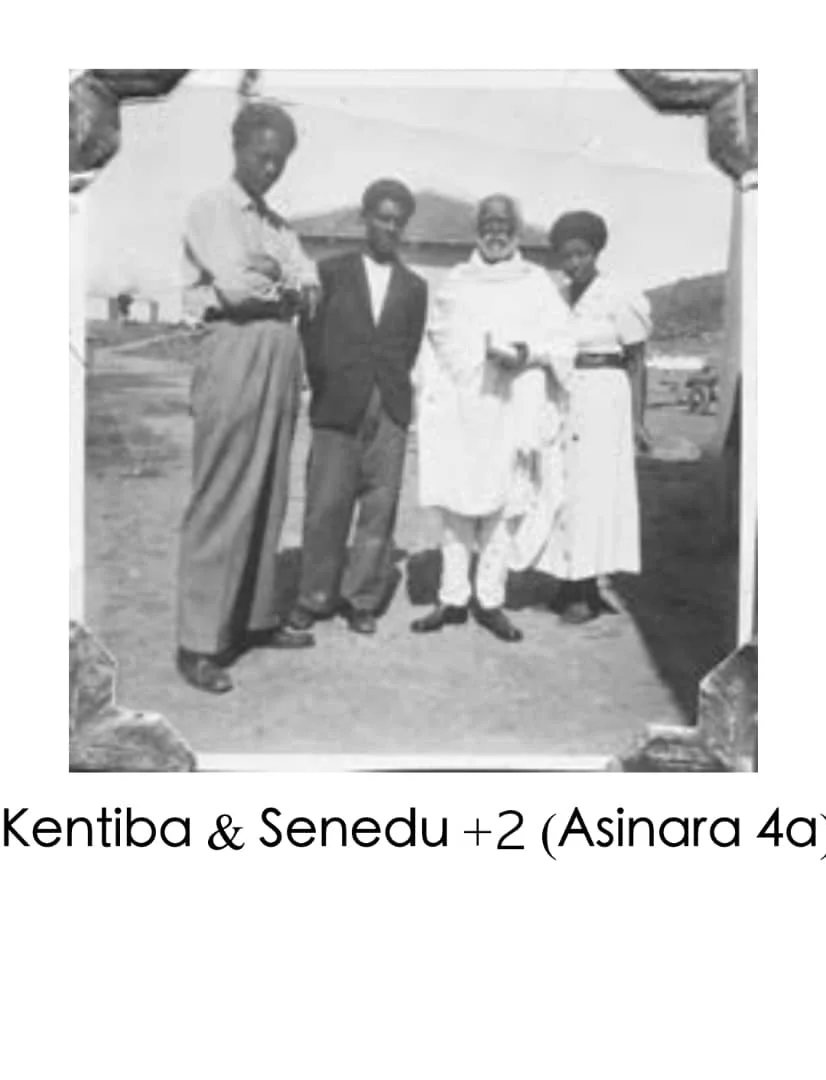 Five people standing outdoors under a canopy, posing for a black-and-white photograph. The group includes two men and three women, dressed in vintage clothing, likely from the early 20th century.