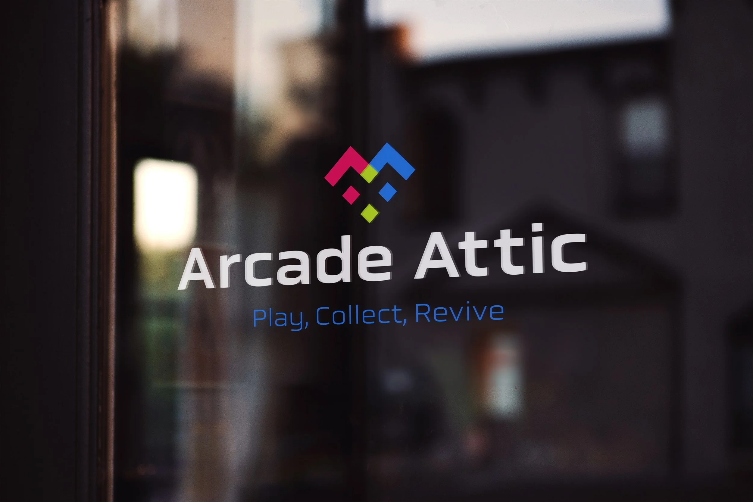 Glass door with Arcade Attic logo and the tagline 'Play, Collect, Revive'.