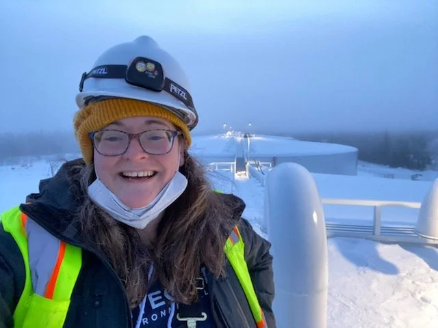 Integrity Environmental team member in safety gear at a remote Alaska fuel storage site in winter conditions