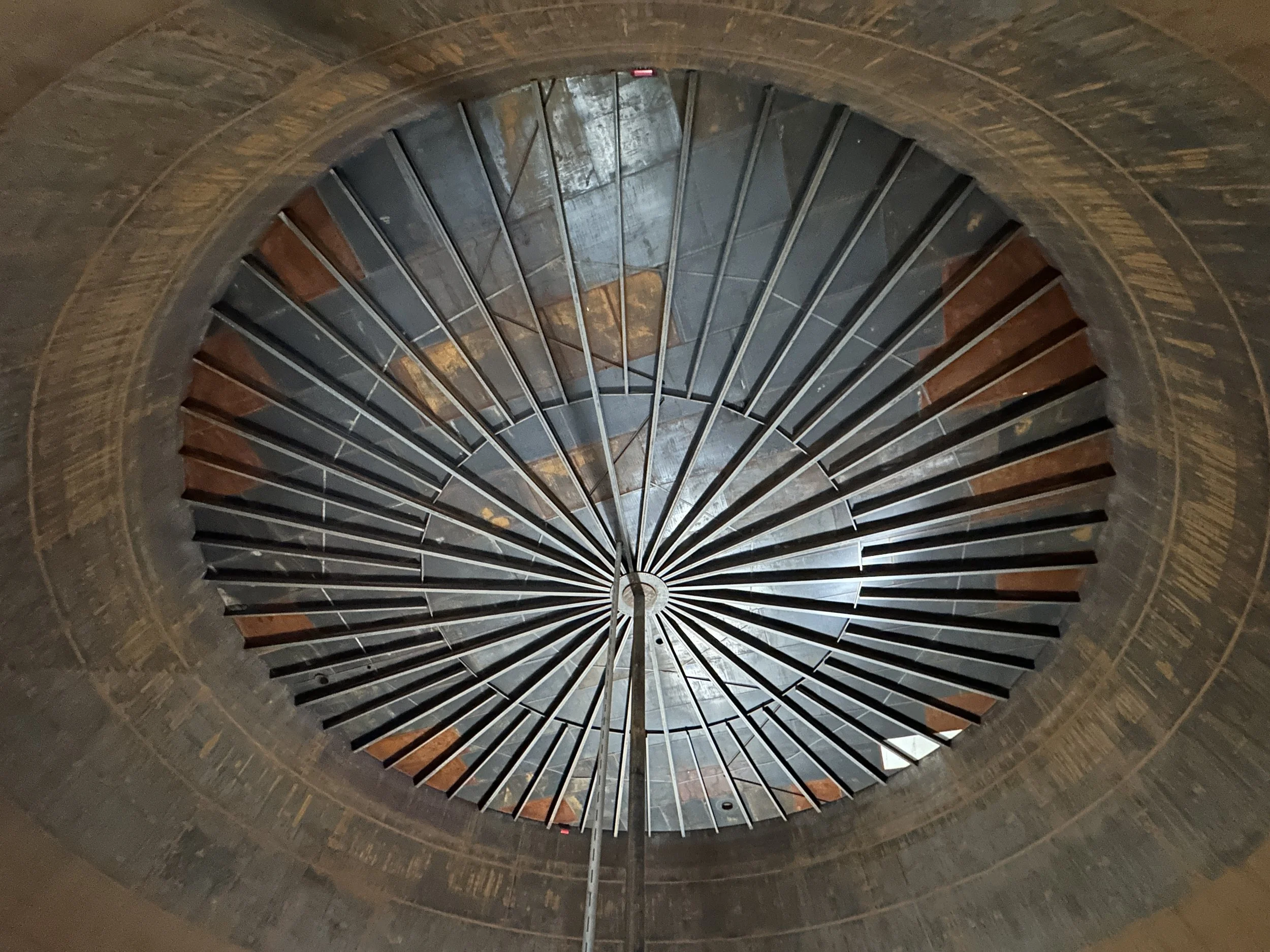 Interior view of an internal floating roof with radial support beams inside a bulk fuel storage tank