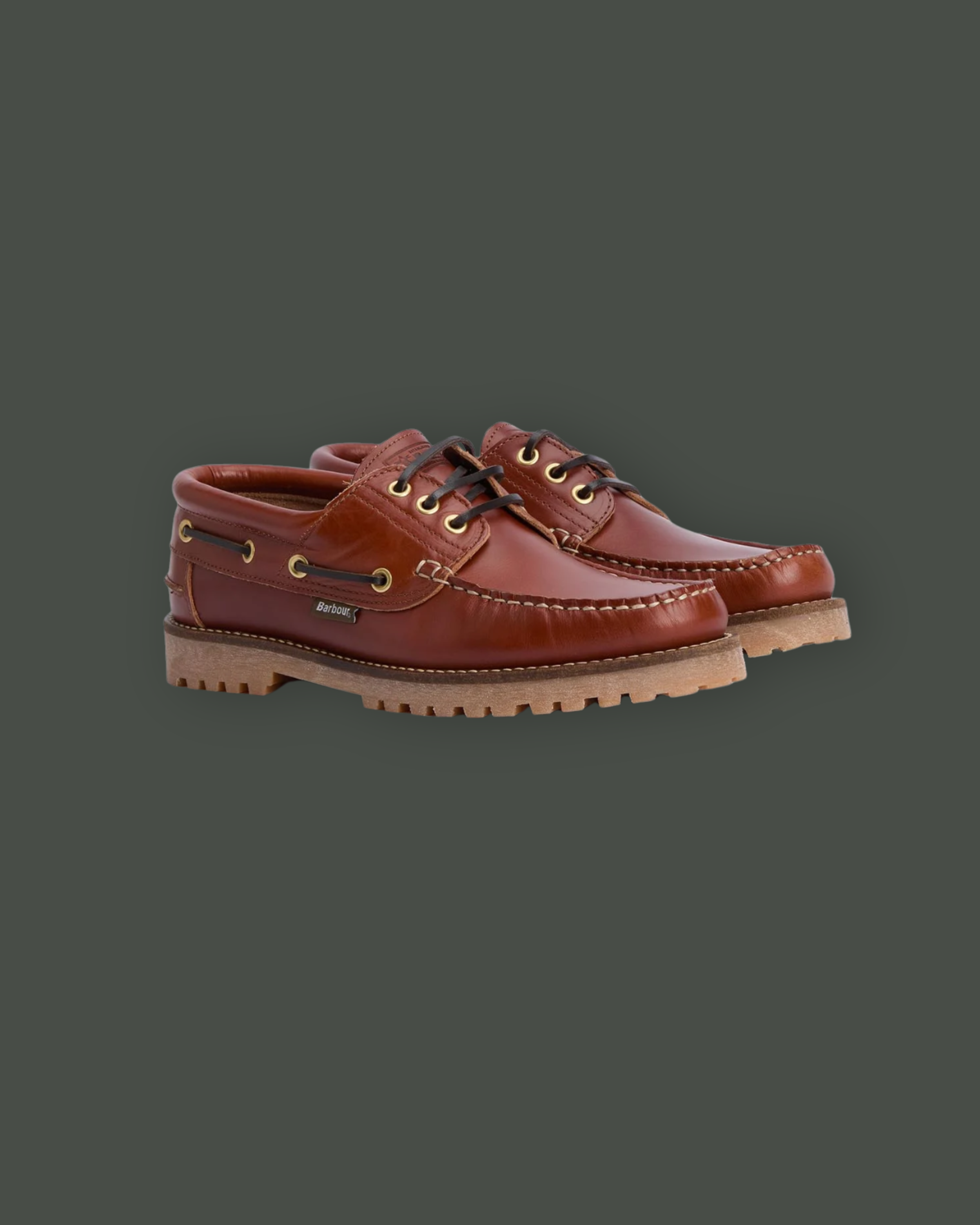 Pair of brown leather boat shoes with black laces and a rugged sole on a dark green background.