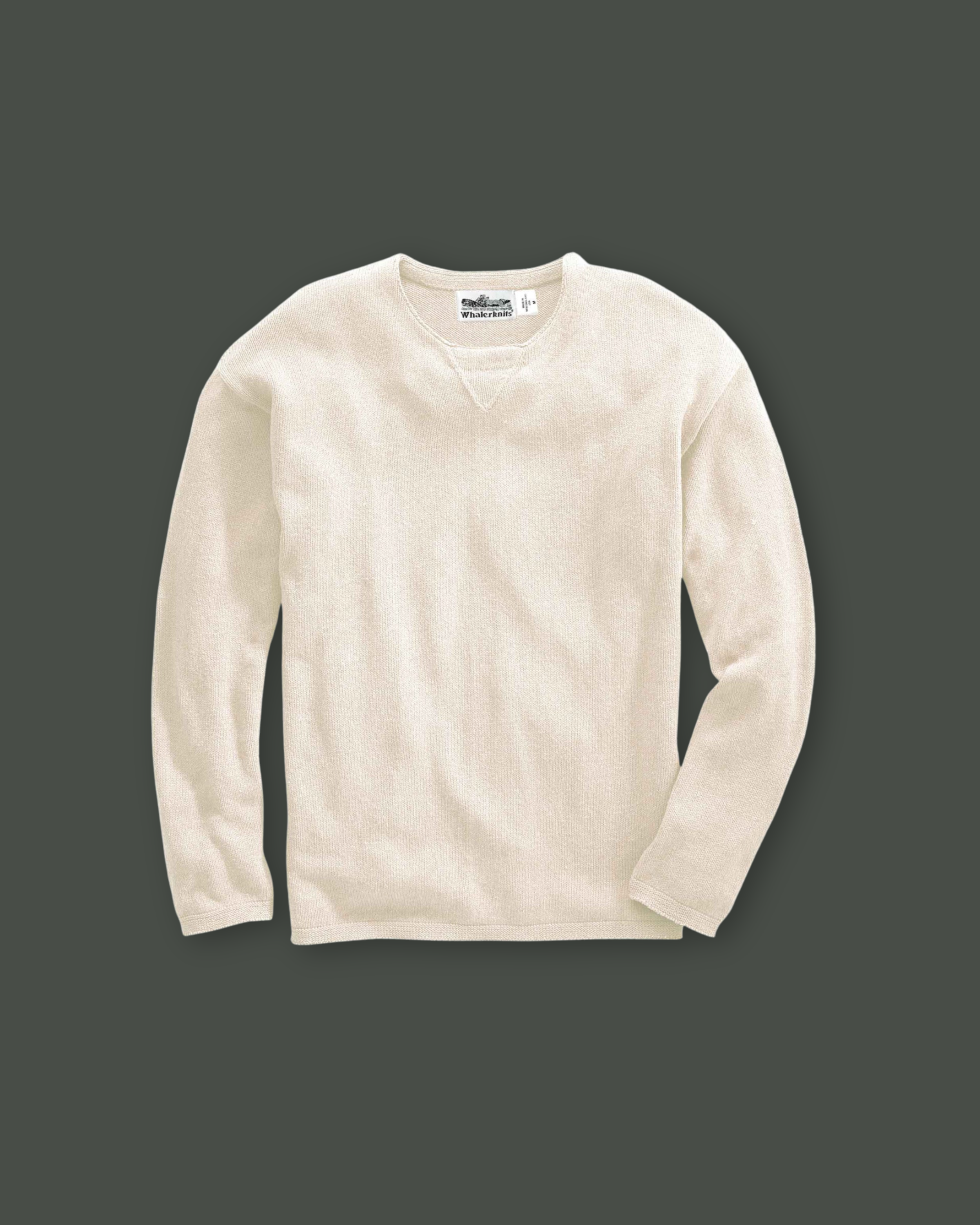 Cream-colored crewneck sweater on dark background.