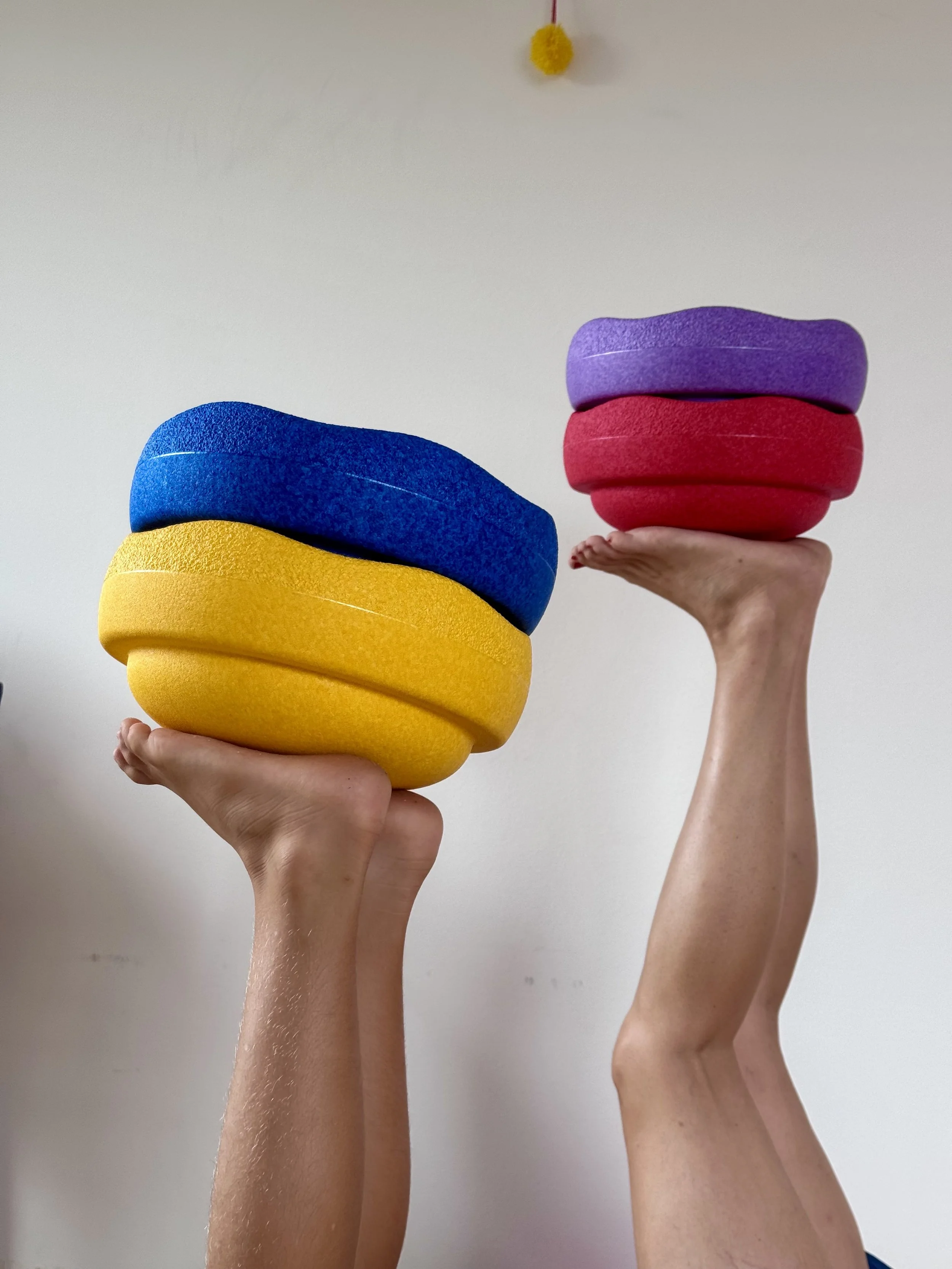 Eltern-Kind-Yoga mit Stapelsteinen auf den Füßen