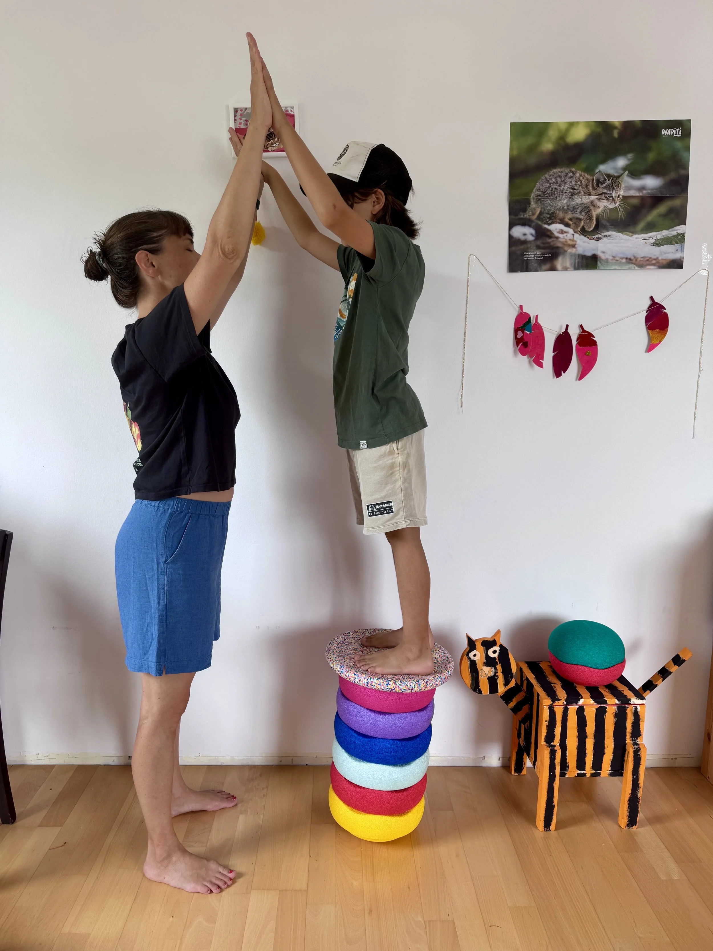 Mutter und Sohn beim gemeinsamen Yoga mit Stapelsteinen