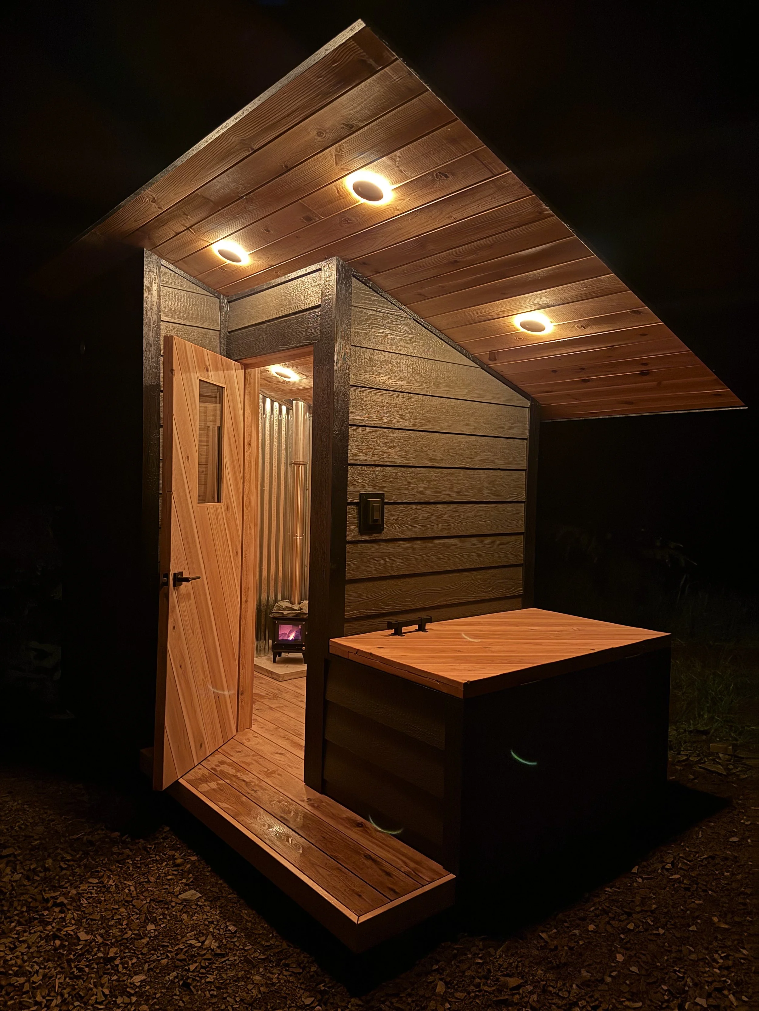 Custom Sauna with cold plunge, built by CUB Saunas, featuring Gray siding, with wood stove, Montana Custom Sauna