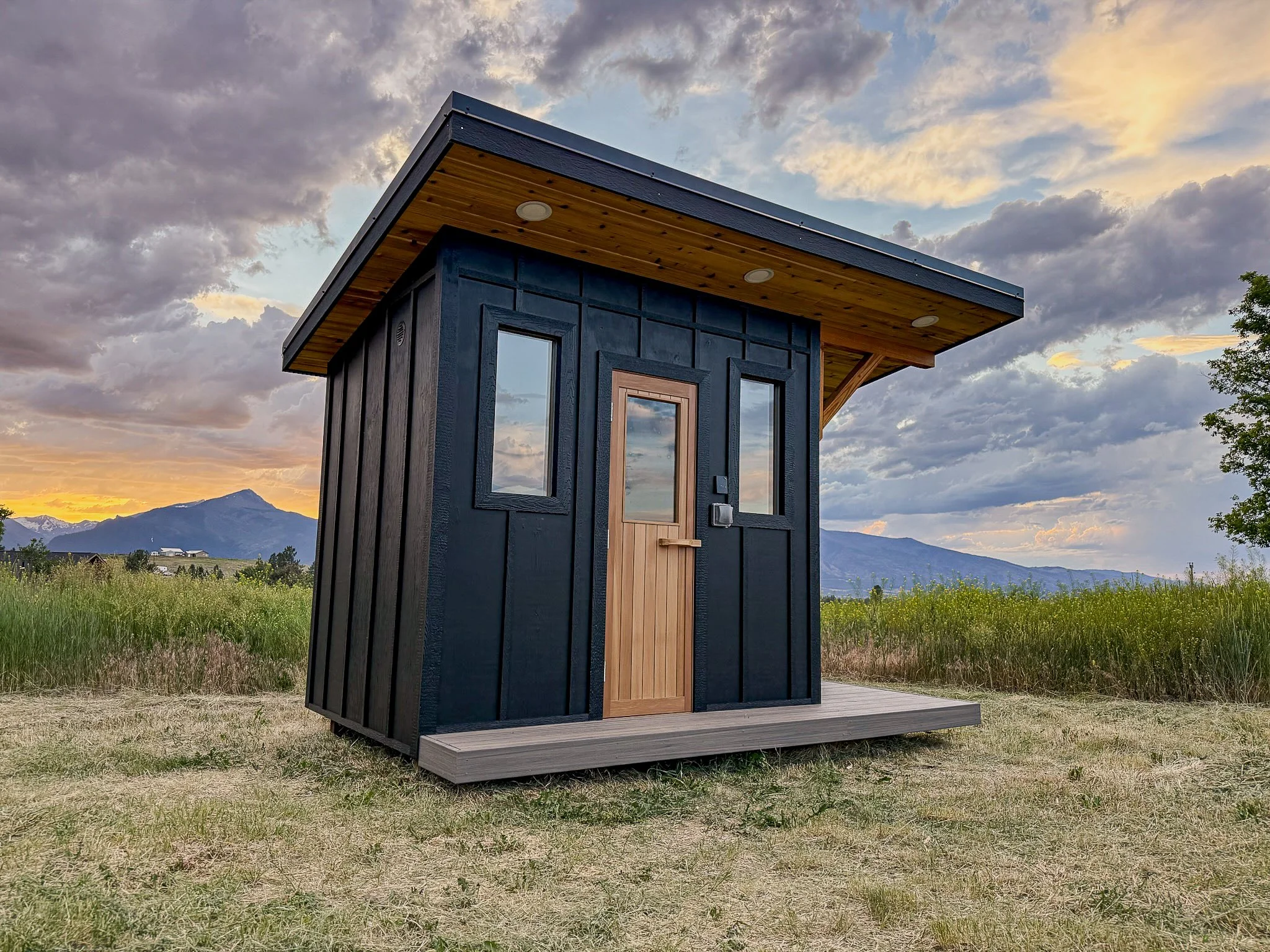 Sauna with black siding and natural wood accents
