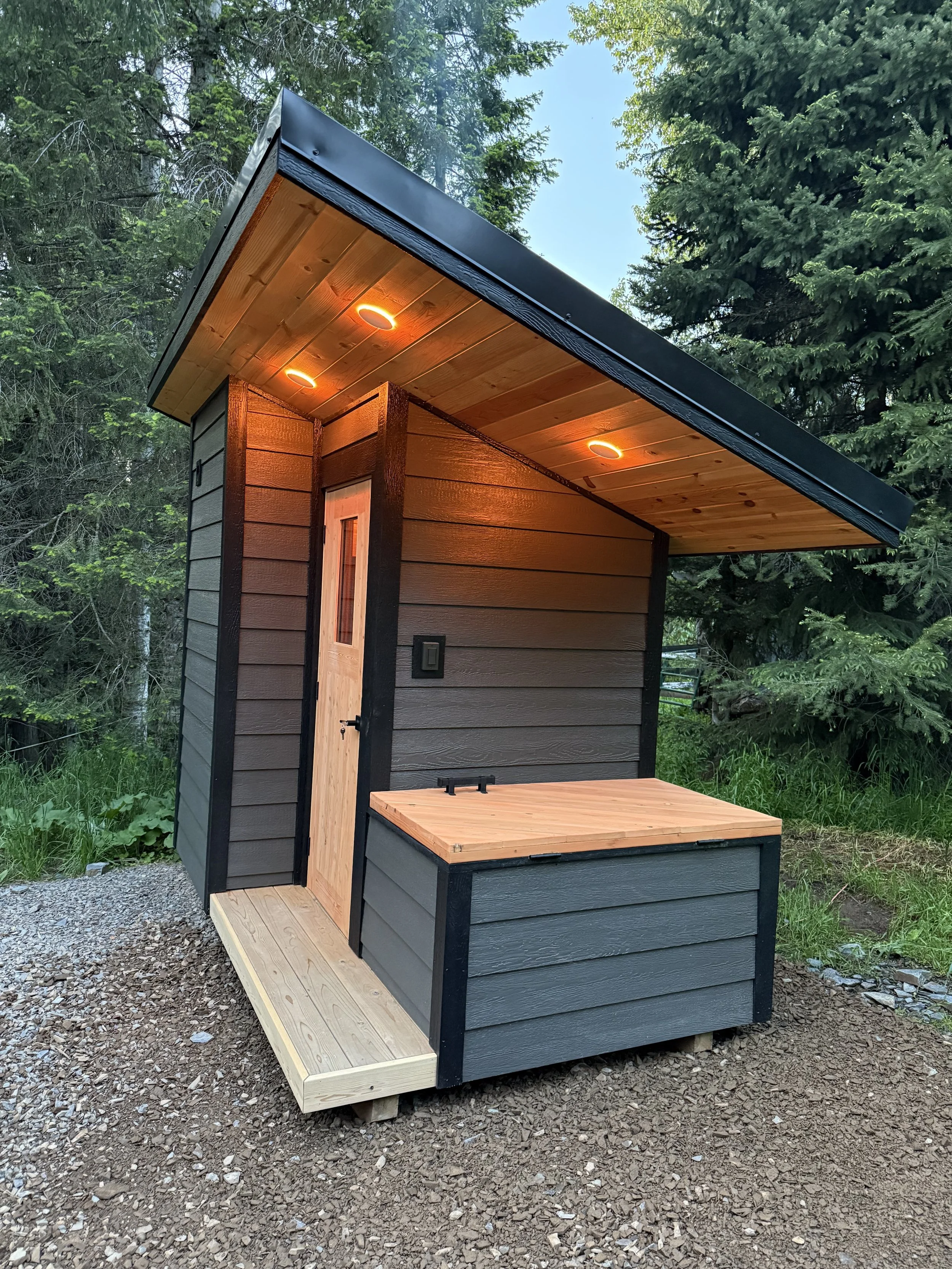 Custom Sauna with cold plunge, built by CUB Saunas, featuring Gray siding, and black trim and roofing, cedar sauna, in Stevensville, Montana