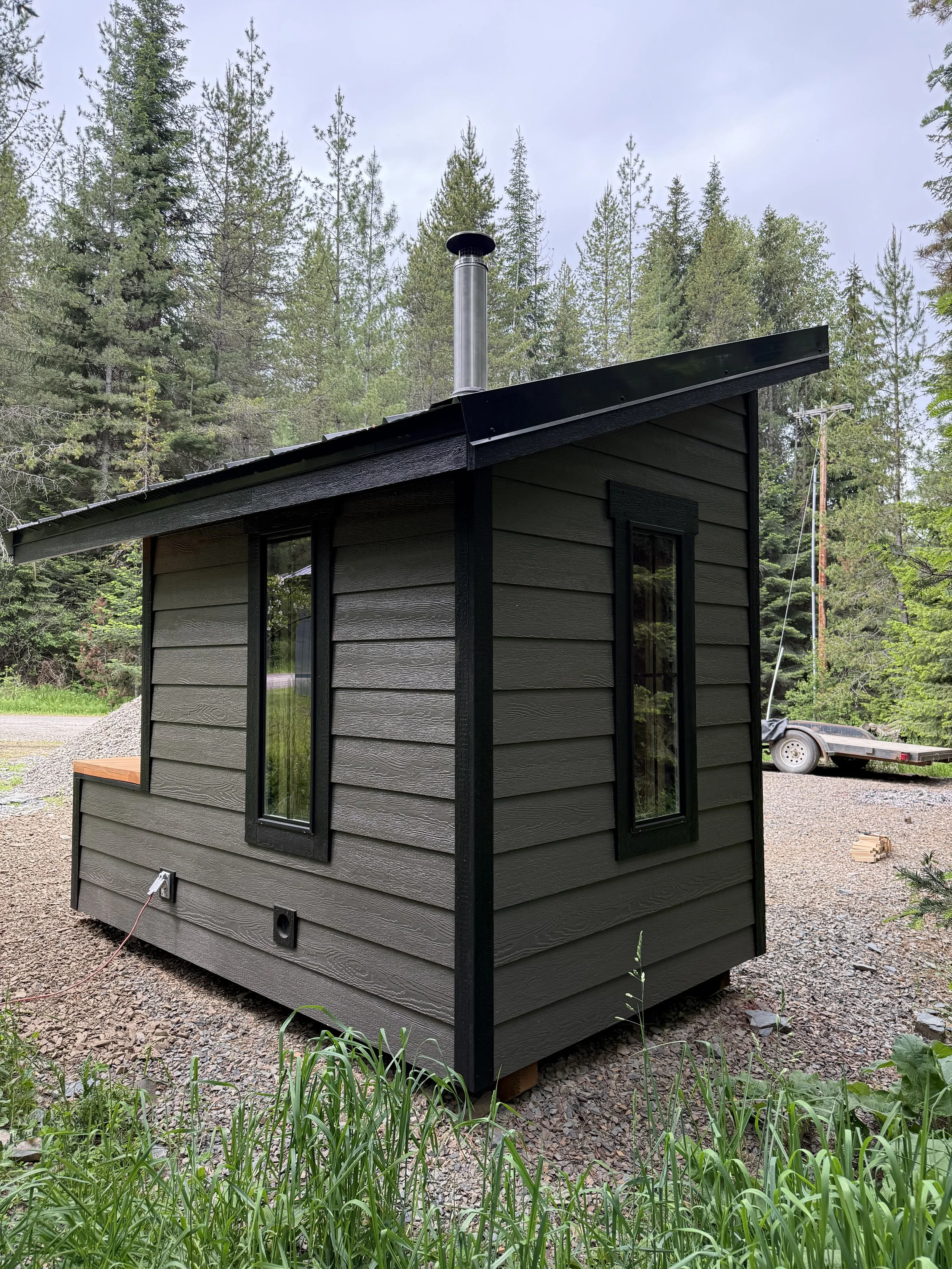Custom Sauna with cold plunge, built by CUB Saunas, gray and black exterior, bluetooth speaker system, and wood stove, in Stevensville, Montana