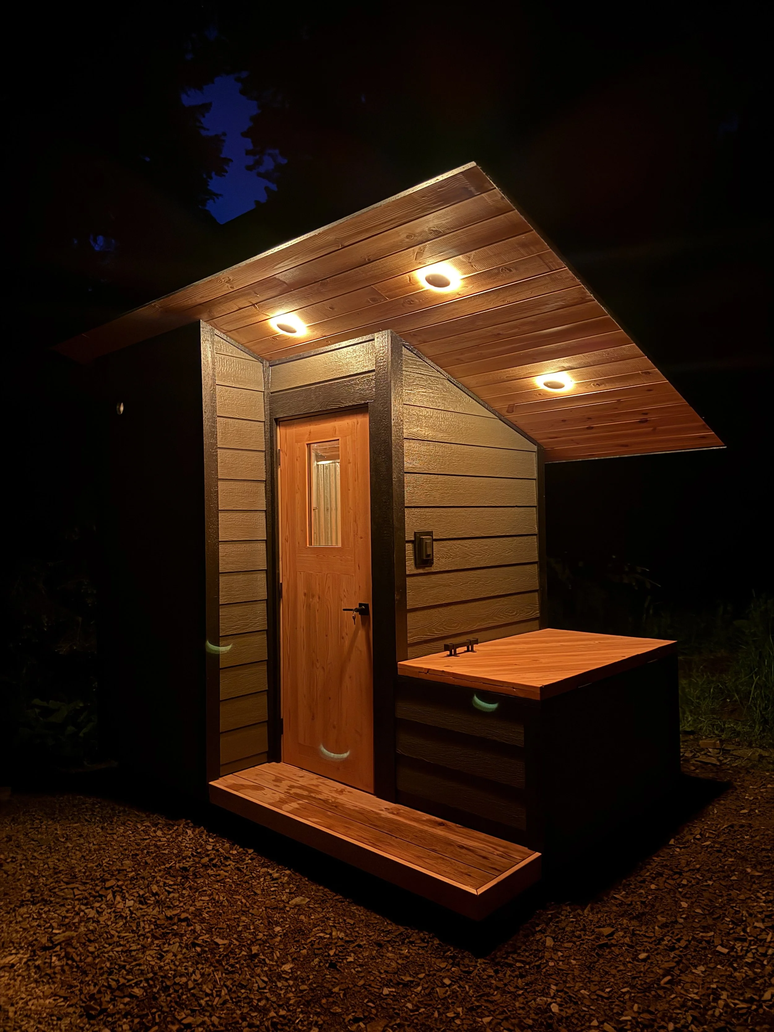Custom Sauna with cold plunge, built by CUB Saunas, featuring Gray siding, and black metal roofing, in Stevensville, Montana