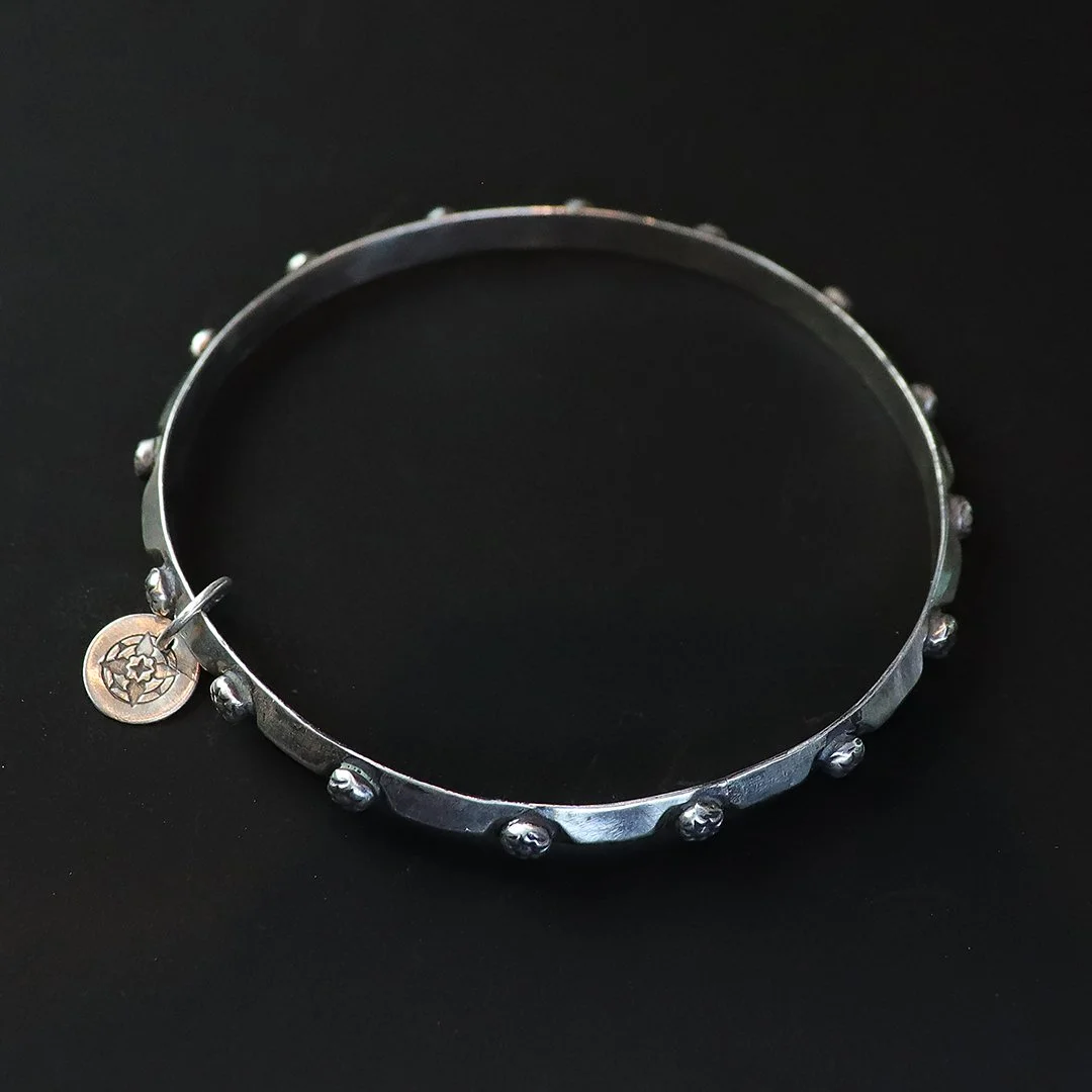 Sterling silver floral bangle bracelet with subtle embedded blossoms