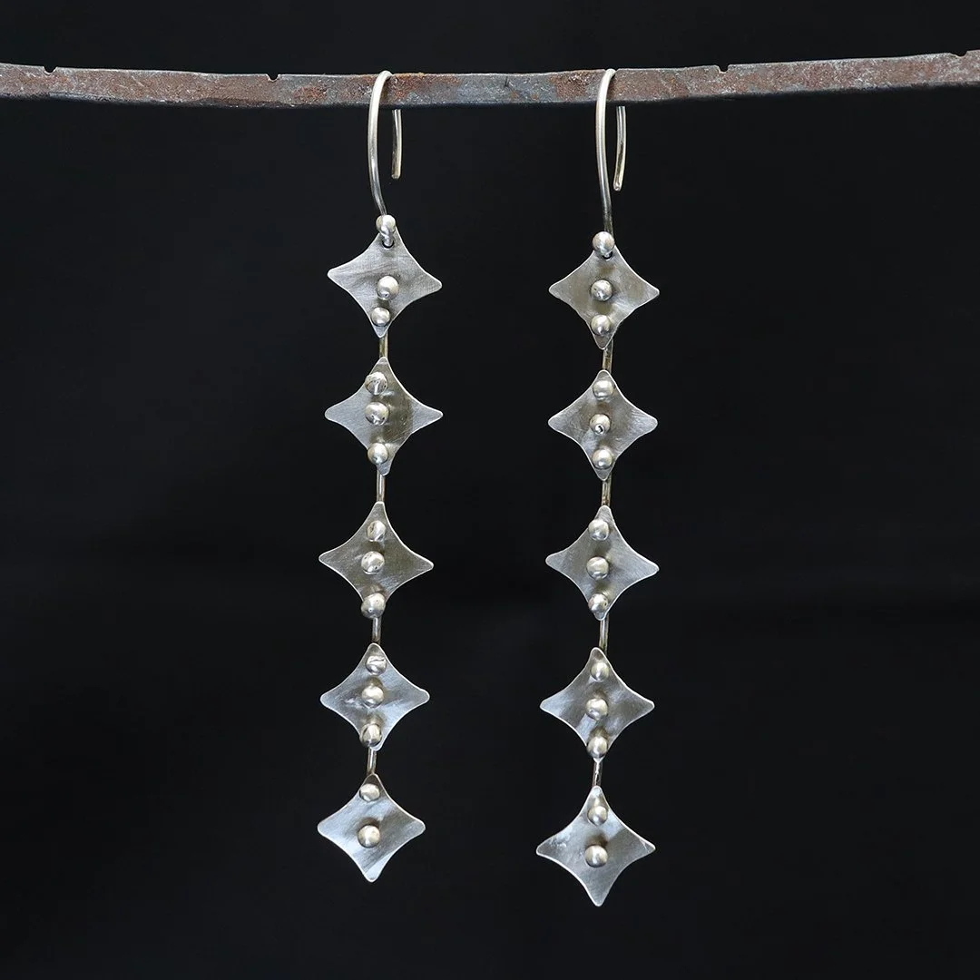 Minimalist sterling silver chain earrings with repeating four-point stars forms
