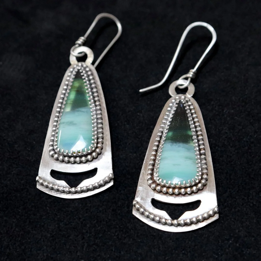 Handmade silver earrings featuring polished opalized wood