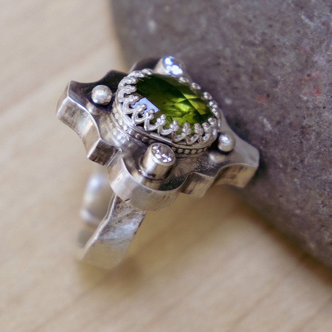 Hand-fabricated silver ring showcasing a peridot gemstone with CZ details