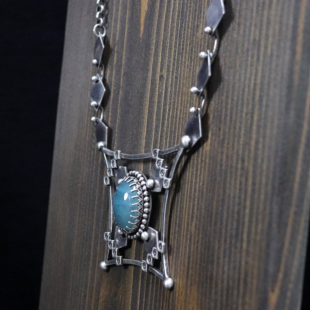 Artisan silver pendant showcasing a blue-green grandidierite stone