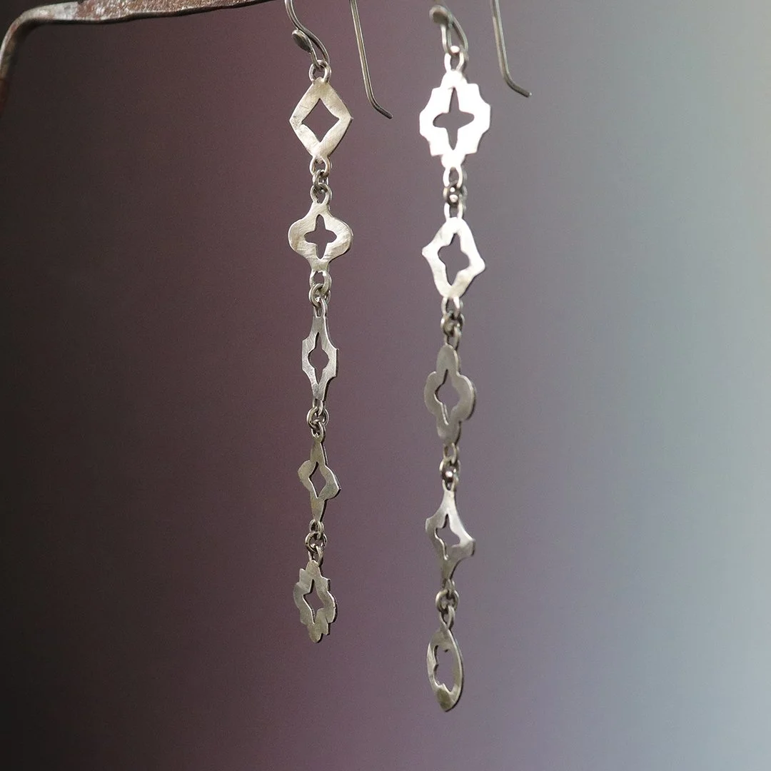 Minimalist silver earrings featuring repeating moroccan motifs