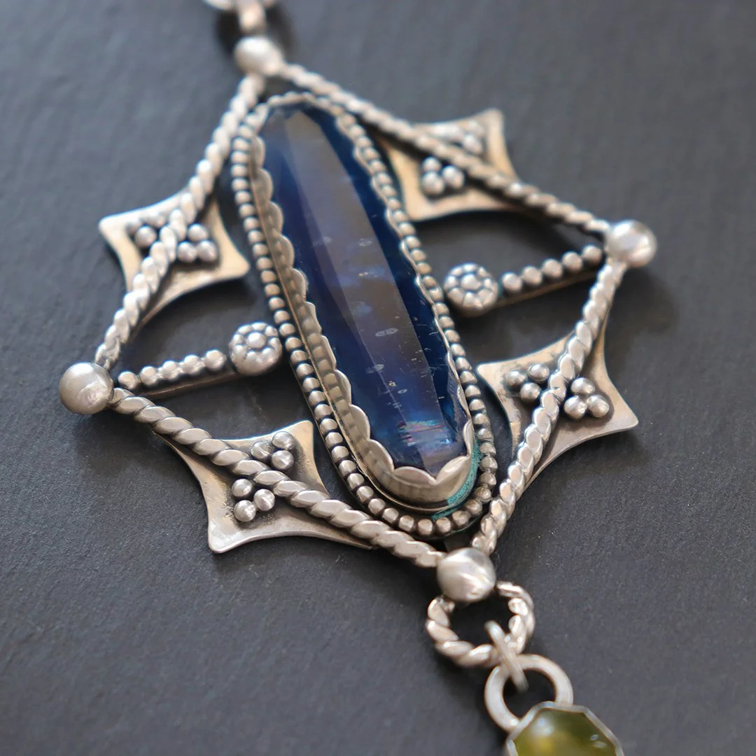 Handcrafted kyanite pendant with geometric silver detailing and serpentine accent