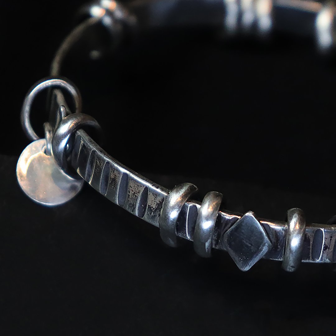 Hand-forged sterling silver bangle with kinetic ring details