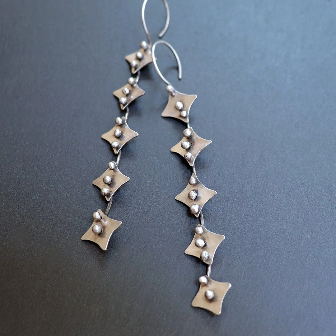 Handmade silver geometric drop earrings with articulated star links