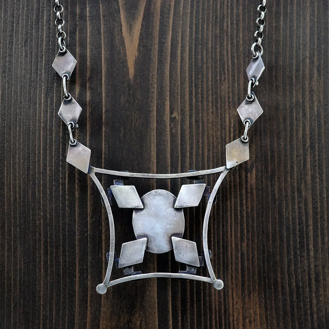 Grandidierite Cabachon set in geometric silver pendant