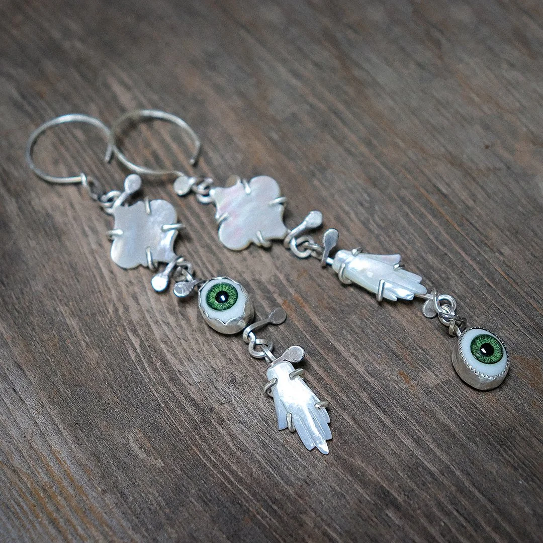 Handmade silver earrings featuring carved mother-of-pearl drops