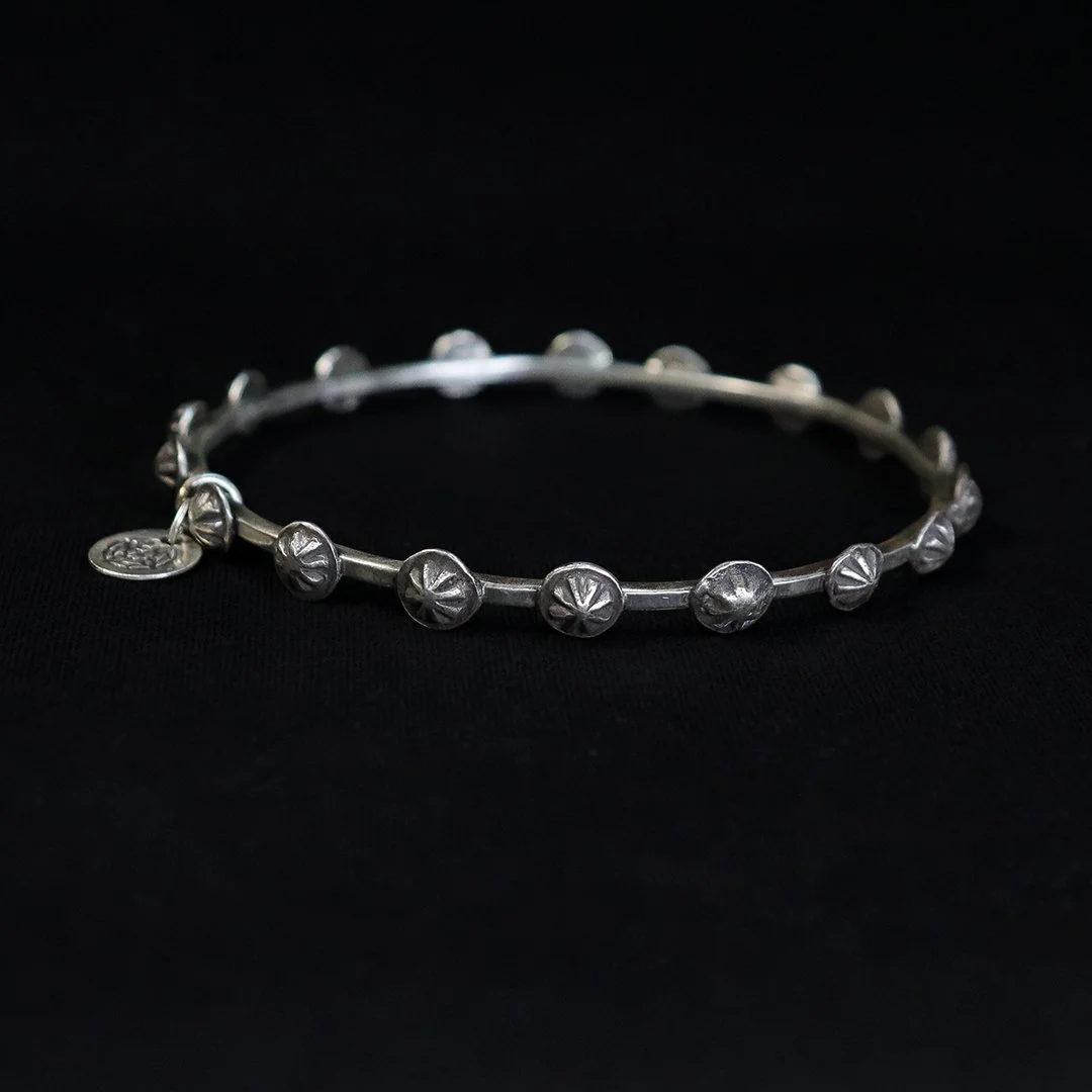 Handmade sterling silver bangle with repeating star motifs and subtle texture