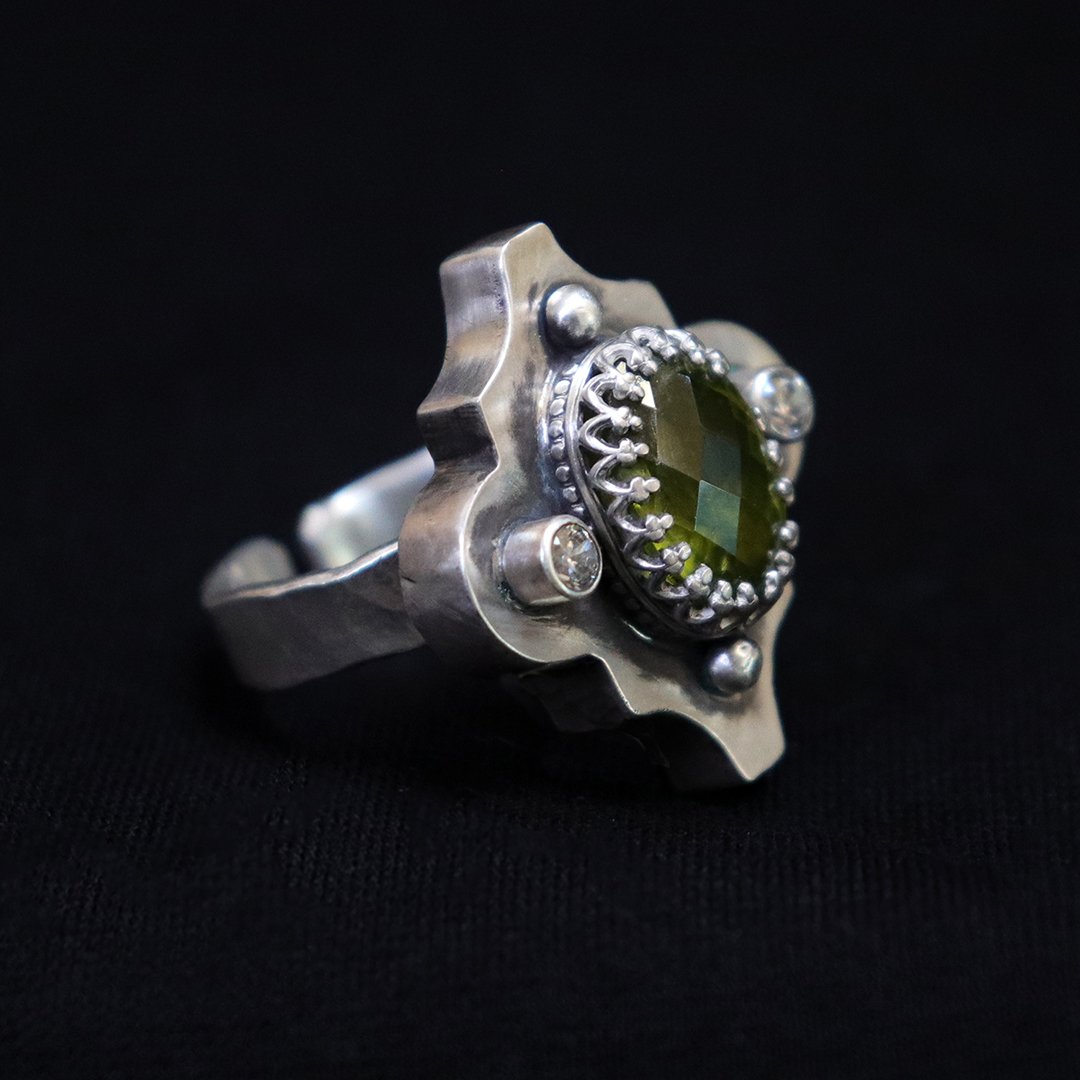 One-of-a-kind silver ring featuring peridot in a hollow form setting with CZs
