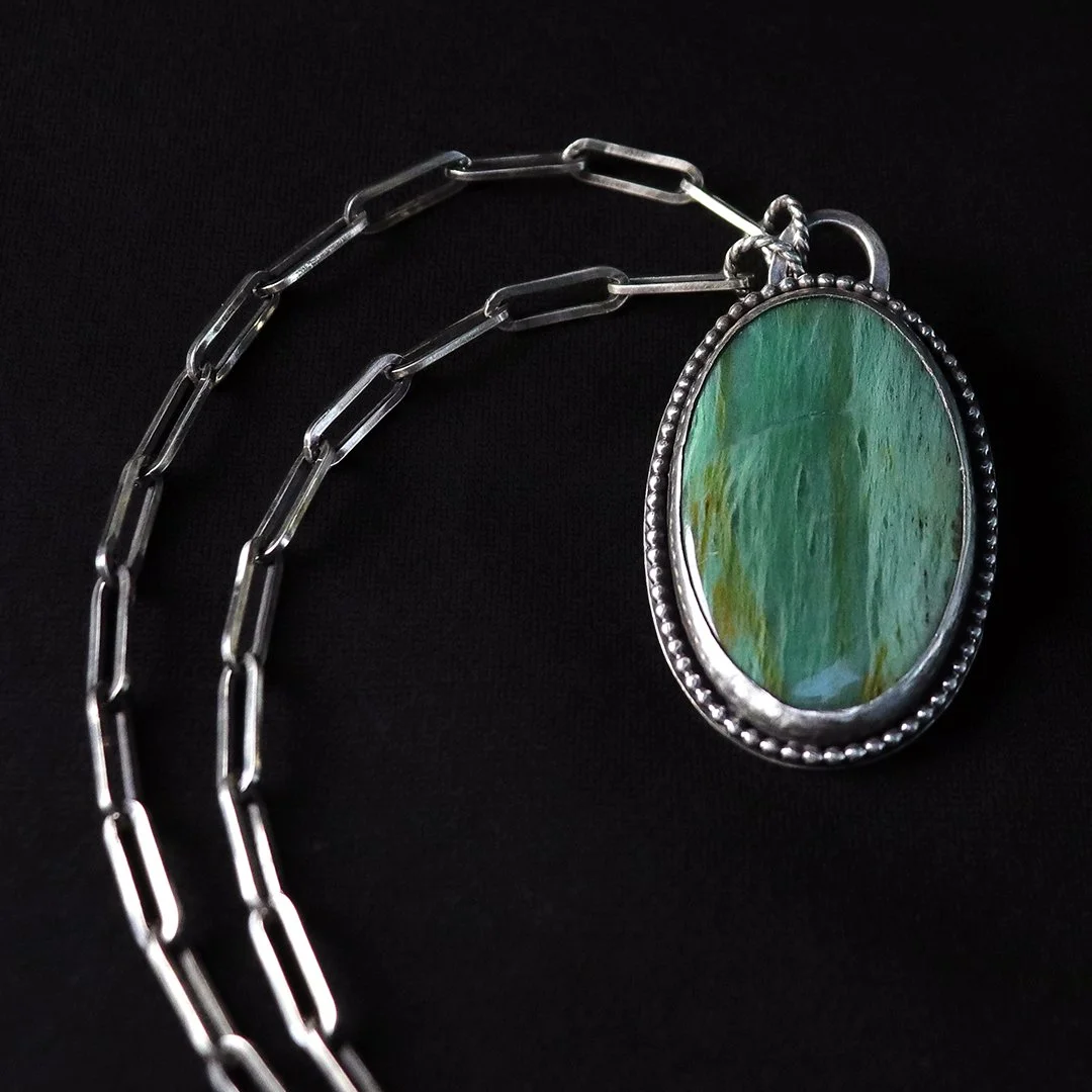 Opalized petrified wood pendant in sterling silver oval setting