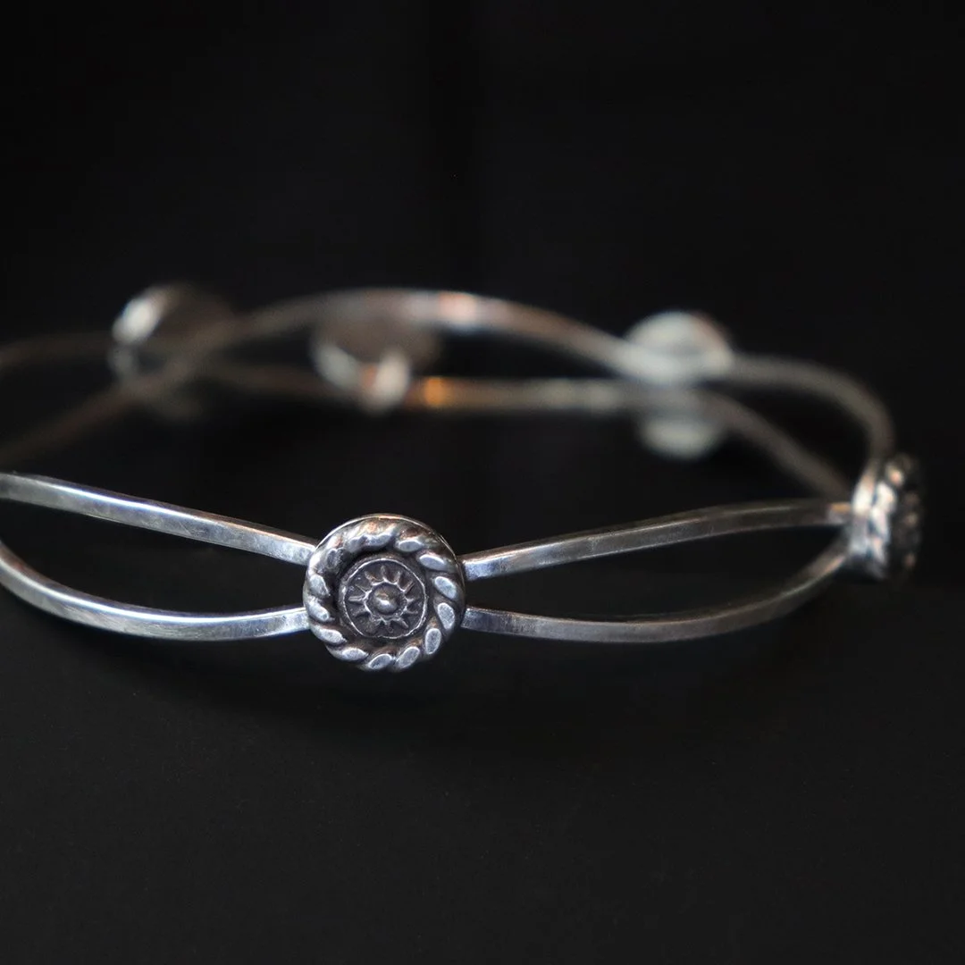 Artisan sterling silver bangle with textured circular motifs