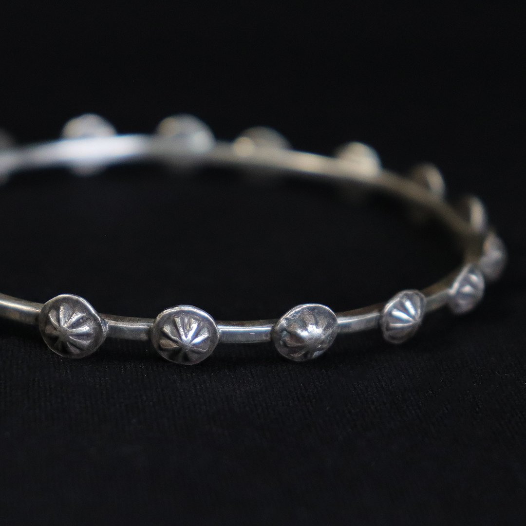 Sterling silver bangle bracelet with star-stamped medallion details, handmade artisan jewelry