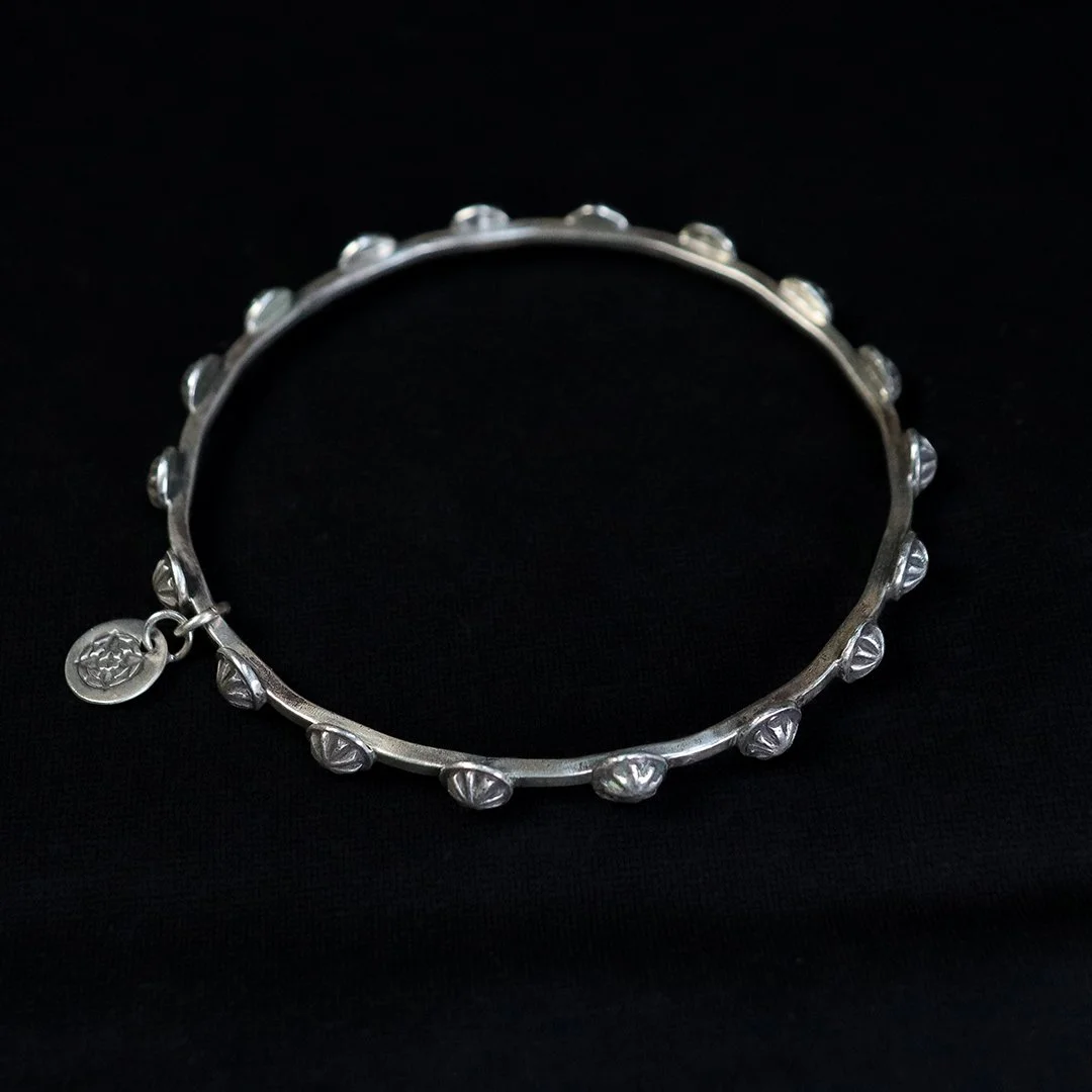 Handmade silver bangle bracelet with celestial star pattern and artisan finish