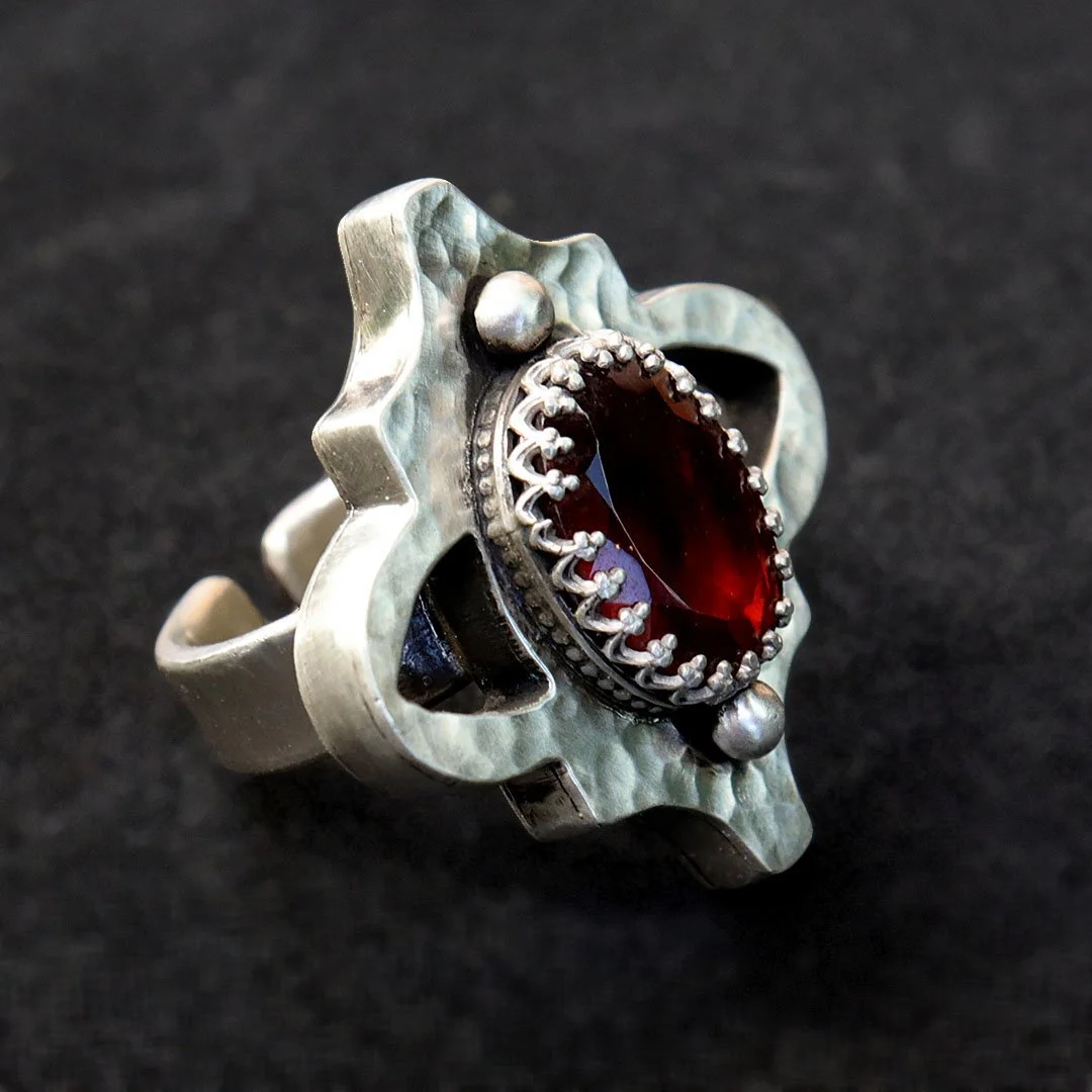 One-of-a-kind silver ring featuring a red garnet in a hollow form setting