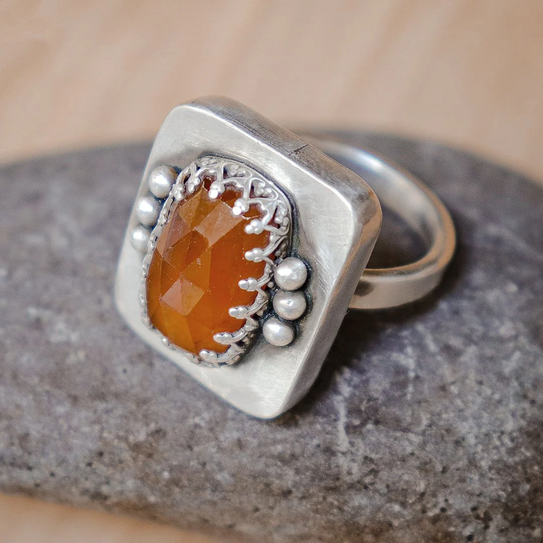 Handmade sterling silver ring featuring a warm hessonite garnet