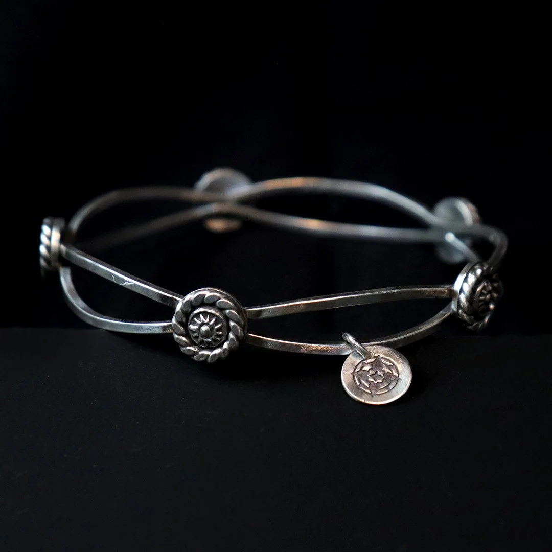 Sterling silver bangle with raised medallion details