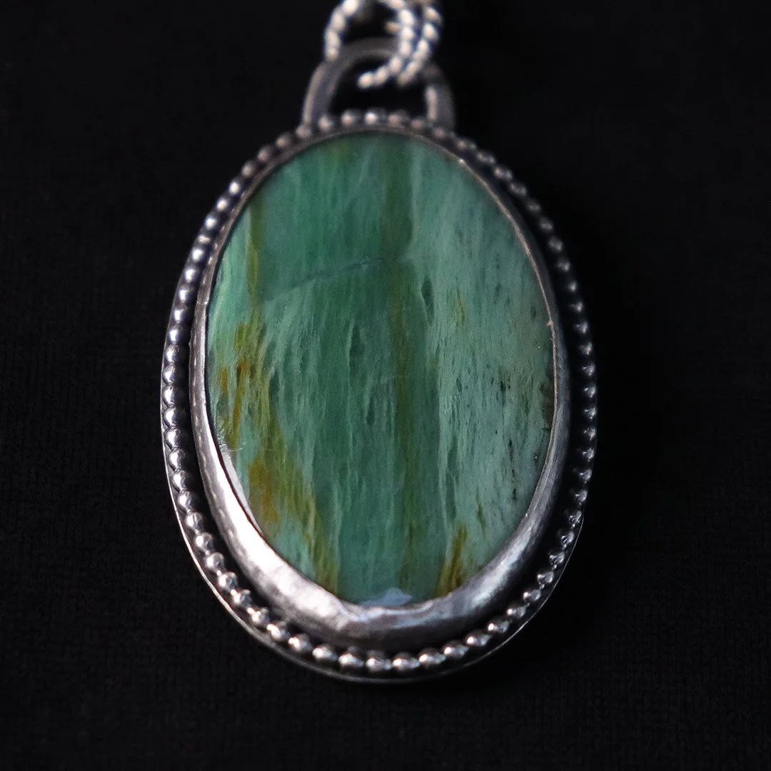 Green opalized wood gemstone pendant with silver beaded edge