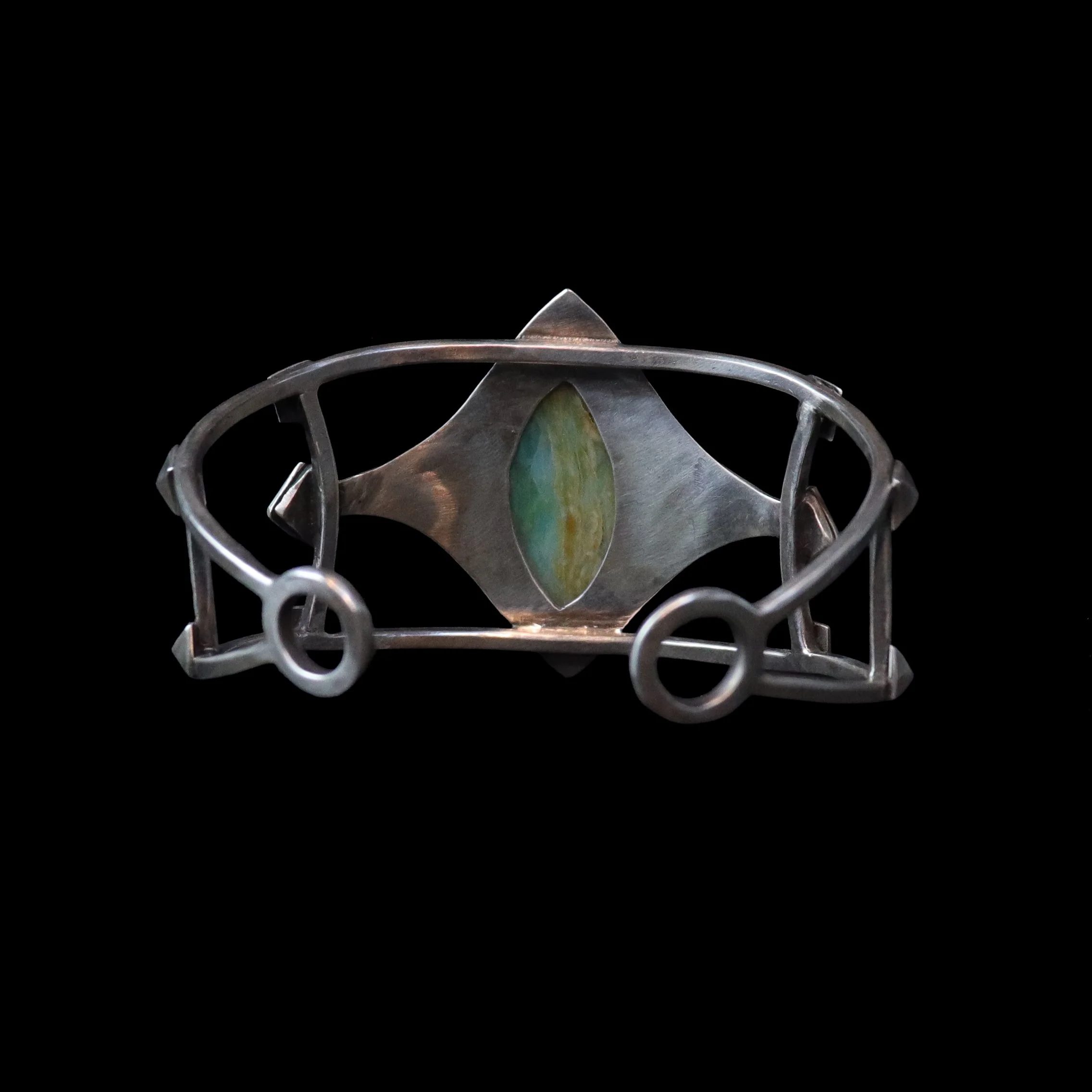 Artisan sterling silver cuff with geometric detailing and green blue stone