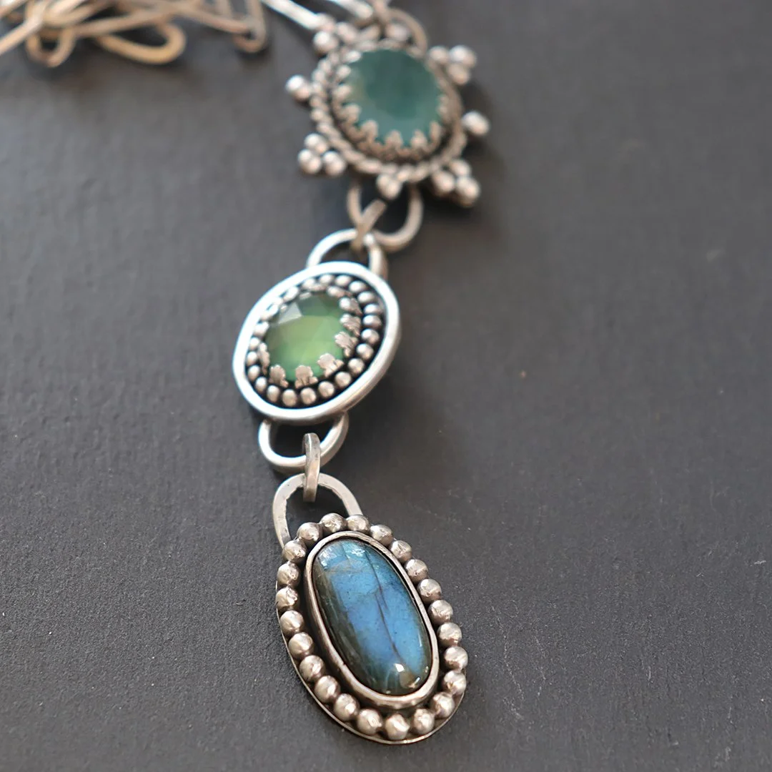 One-of-a-kind silver pendant featuring blue-green gemstones including grandidierite, serpentine, and labradorite