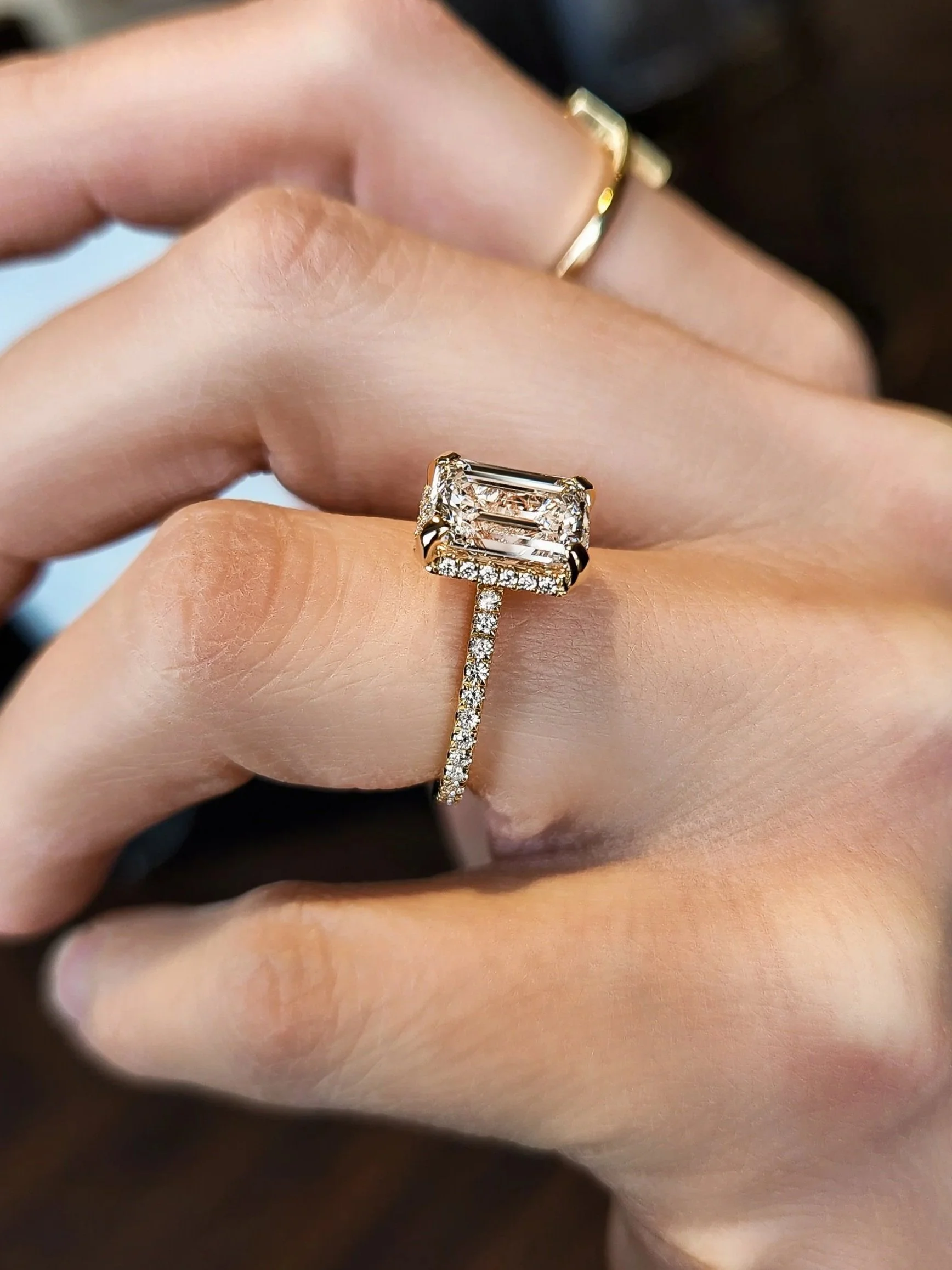 Emerald cut diamond engagement ring with drop halo set in 14K yellow gold