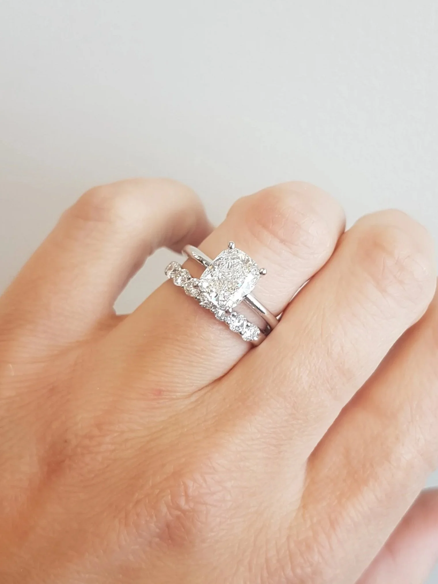 Cusion cut diamond engagement ring with shared prong diamond wedding band