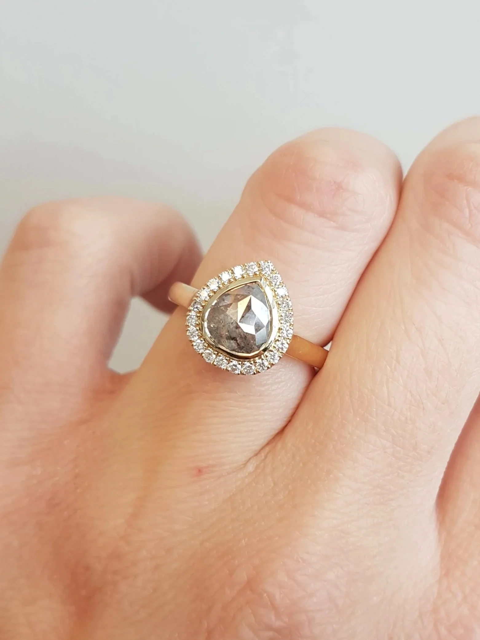 Pear shaped salt and pepper diamond set in diamond halo engagement ring, 14K yellow gold