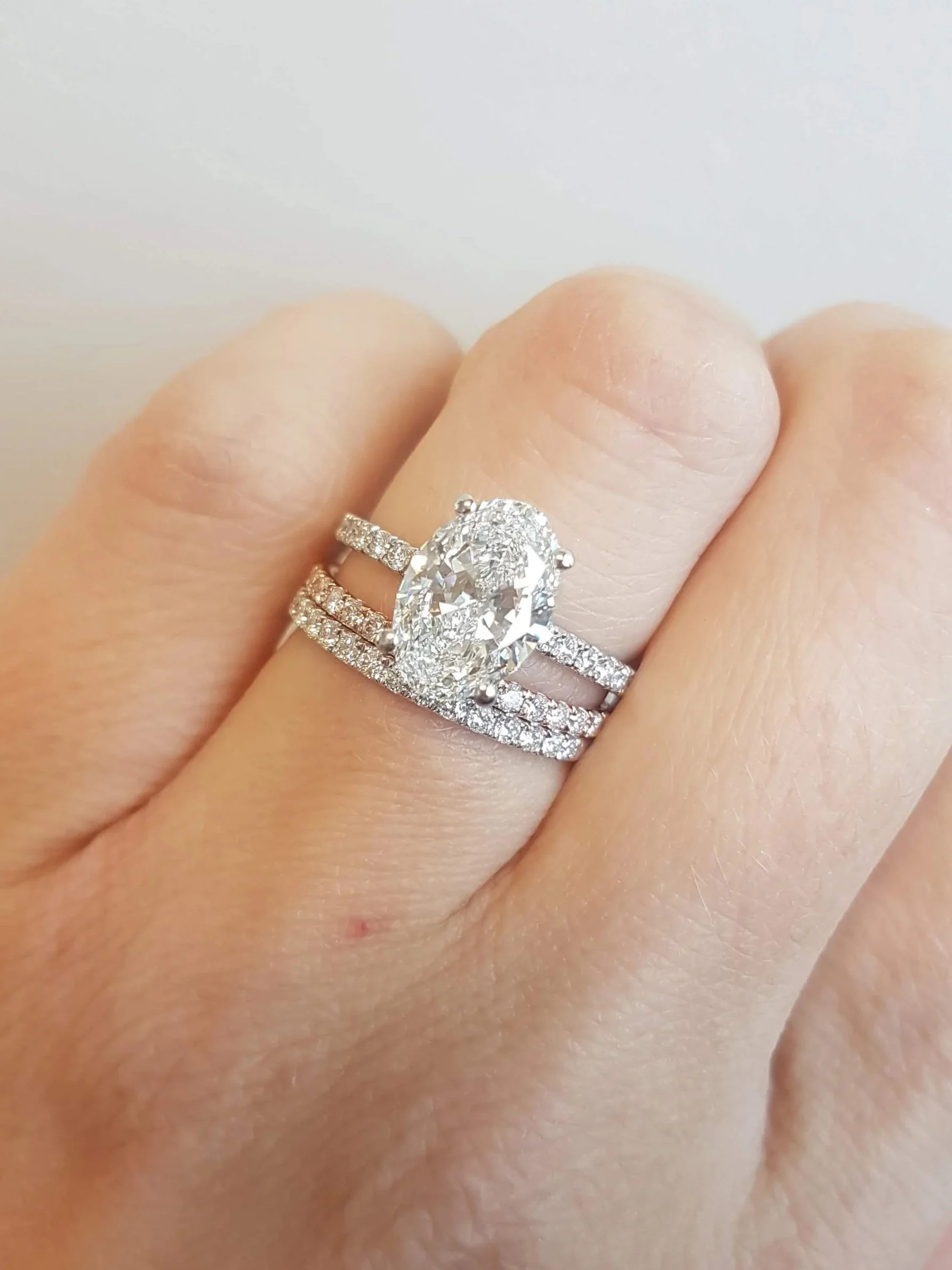 Oval cut diamond band engagement ring with matching diamond wedding bands