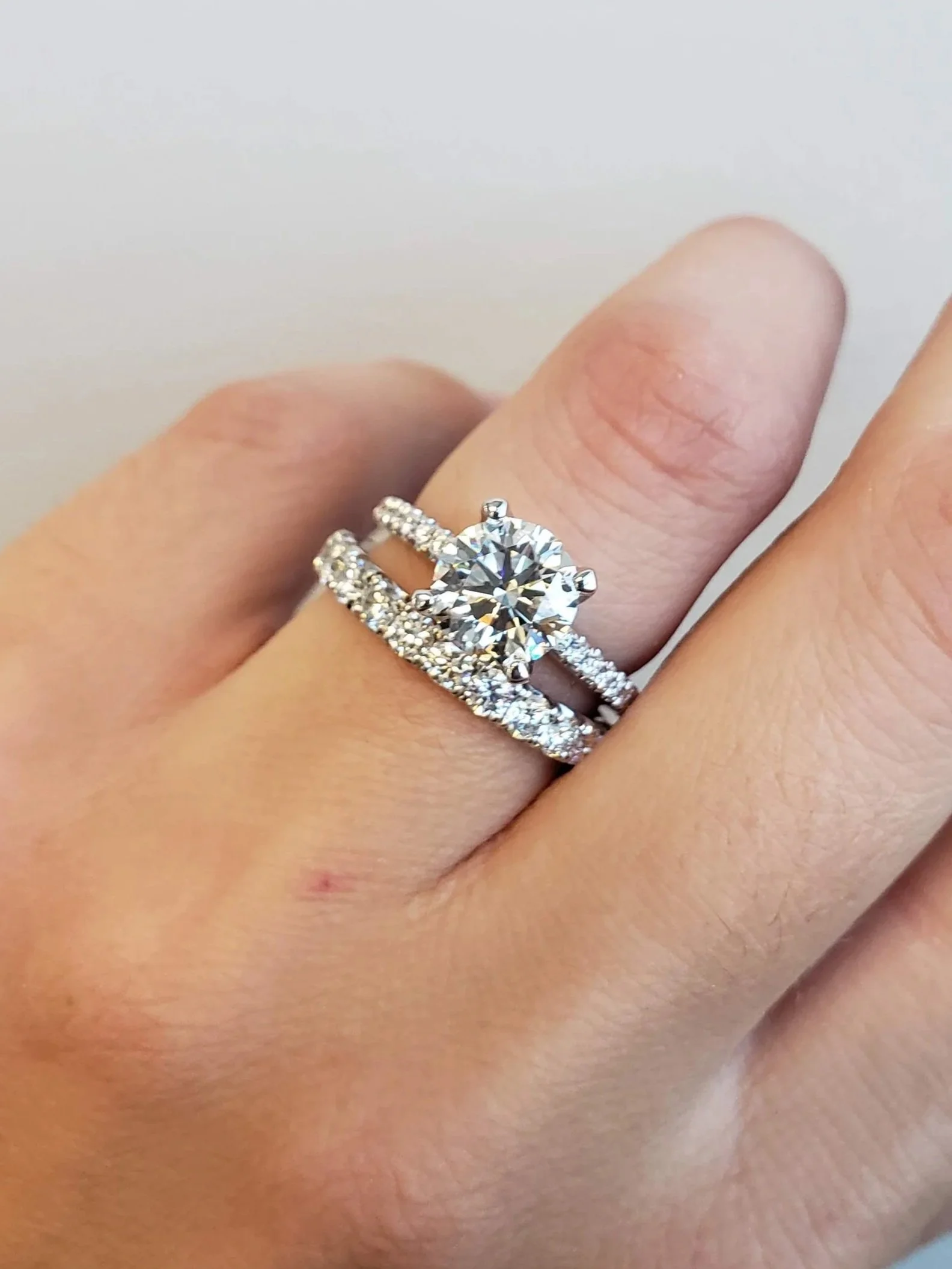 Round brilliant cut diamond engagement ring with scalloped diamond wedding band
