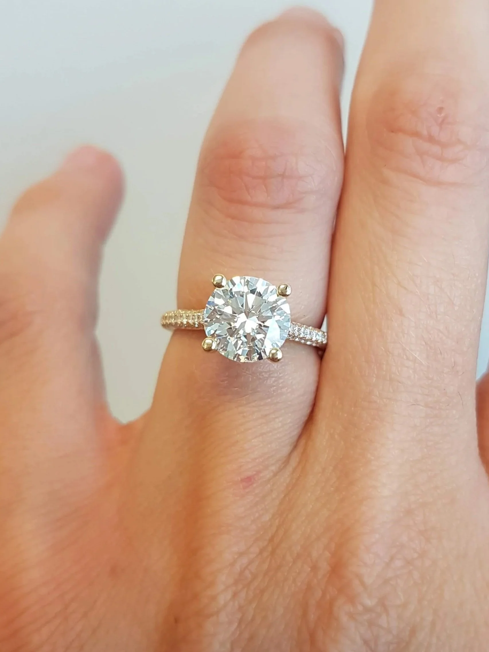 Round brilliant cut engagement ring with micro pave band