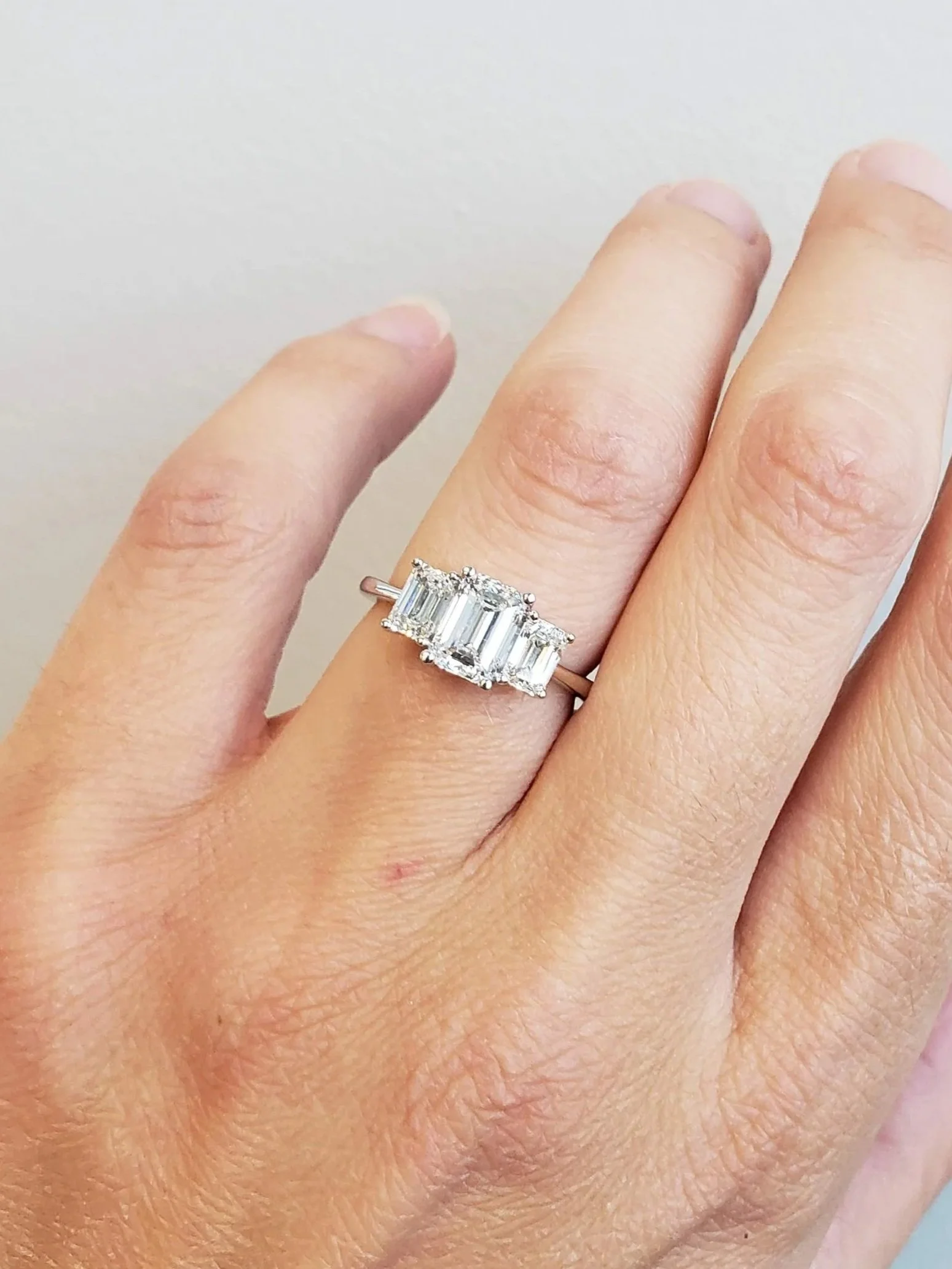 Three stone emerald cut diamond engagement ring