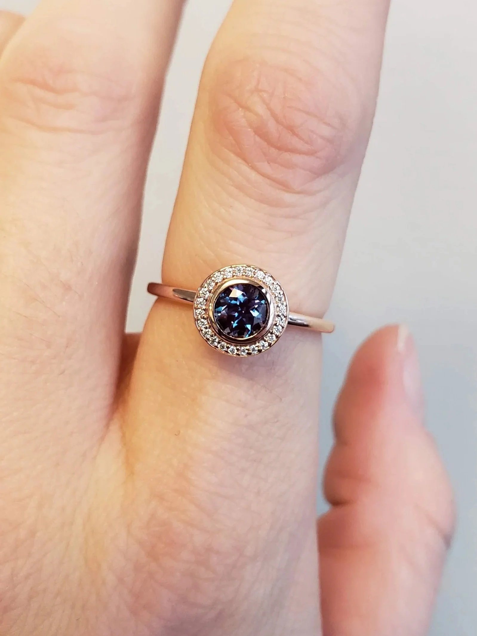 Alexandrite centre bezel set into rose gold halo engagement ring setting