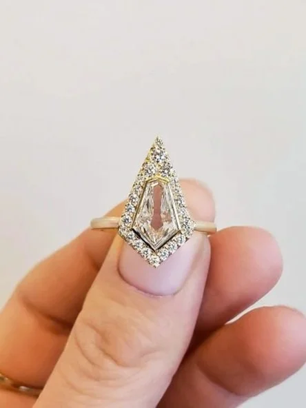 Kite shaped diamond engagement ring with pave set halo set in 14K yellow gold